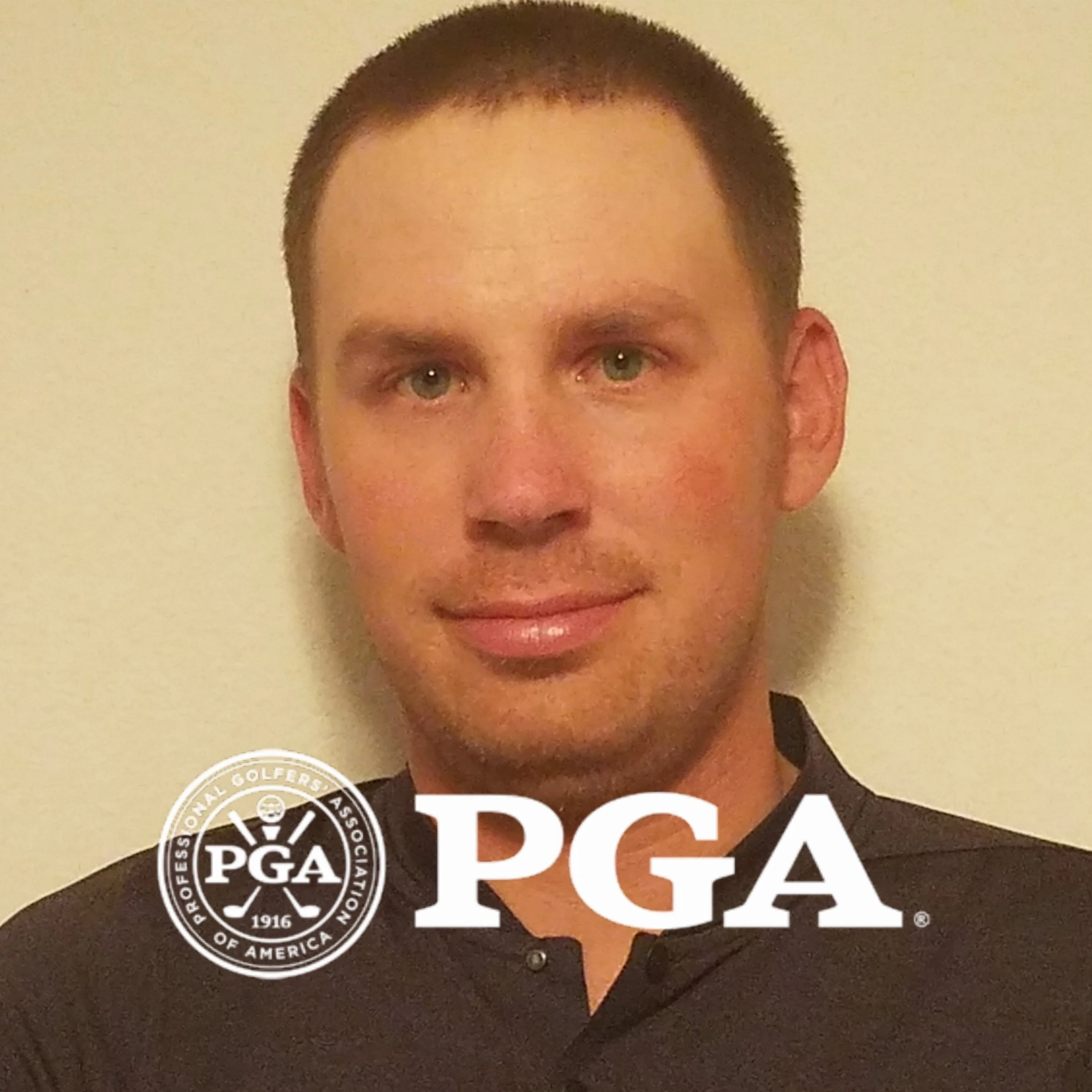 A man with short brown hair and blue eyes, wearing a dark shirt, is smiling slightly at the camera in front of a light-colored background. Overlaid on the image are the PGA and Professional Golfers' Association of America logos.