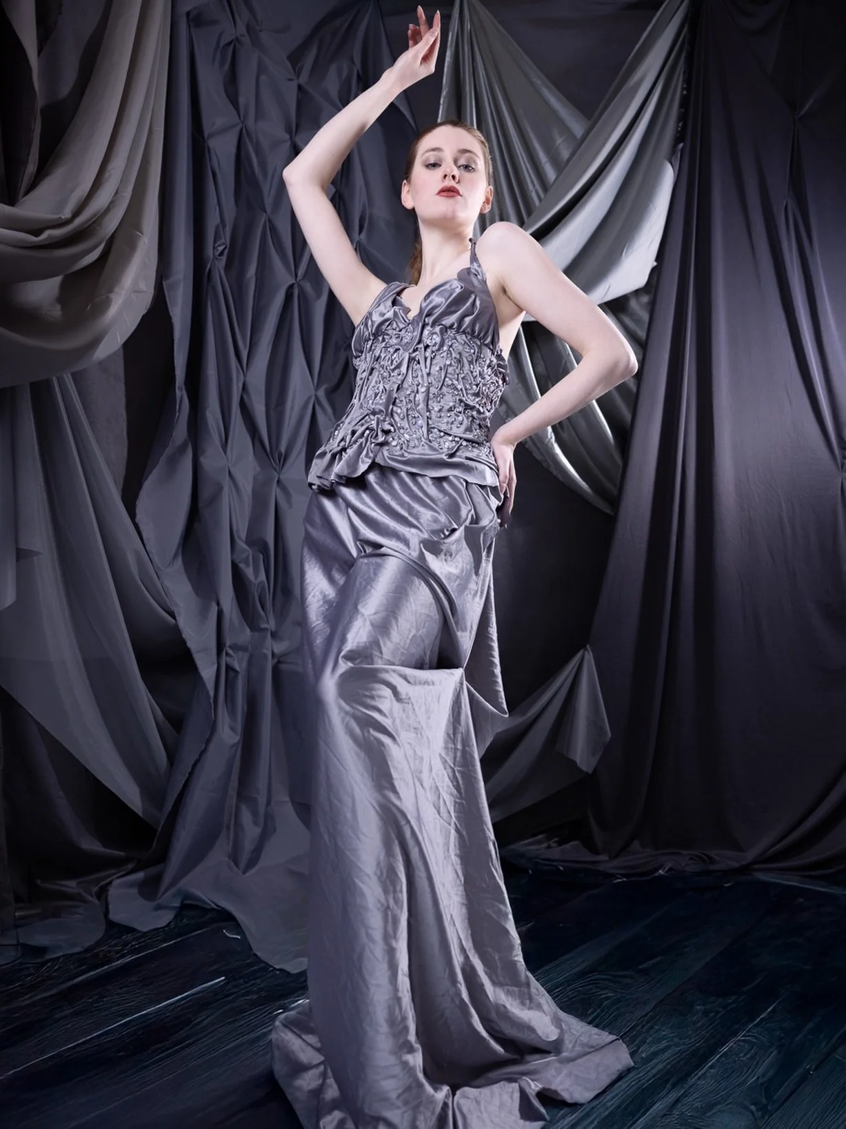 Wrapped in light and fabric, she becomes part of the scene rather than simply standing within it.

I wanted this image to feel like a moment suspended between movement and stillness, where the folds of the dress and the draped backdrop mirror each ot