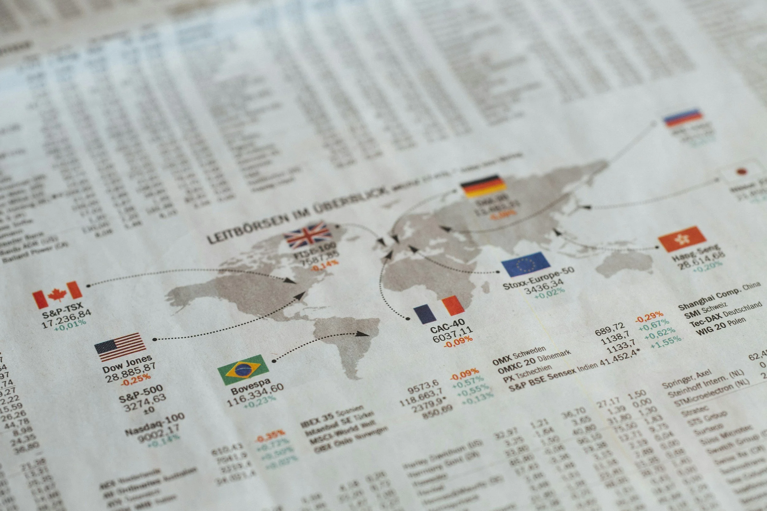 A world map showing stock market indices and financial data, including flags of Canada, the United States, Brazil, France, Germany, China, and Switzerland, along with corresponding stock exchange information.