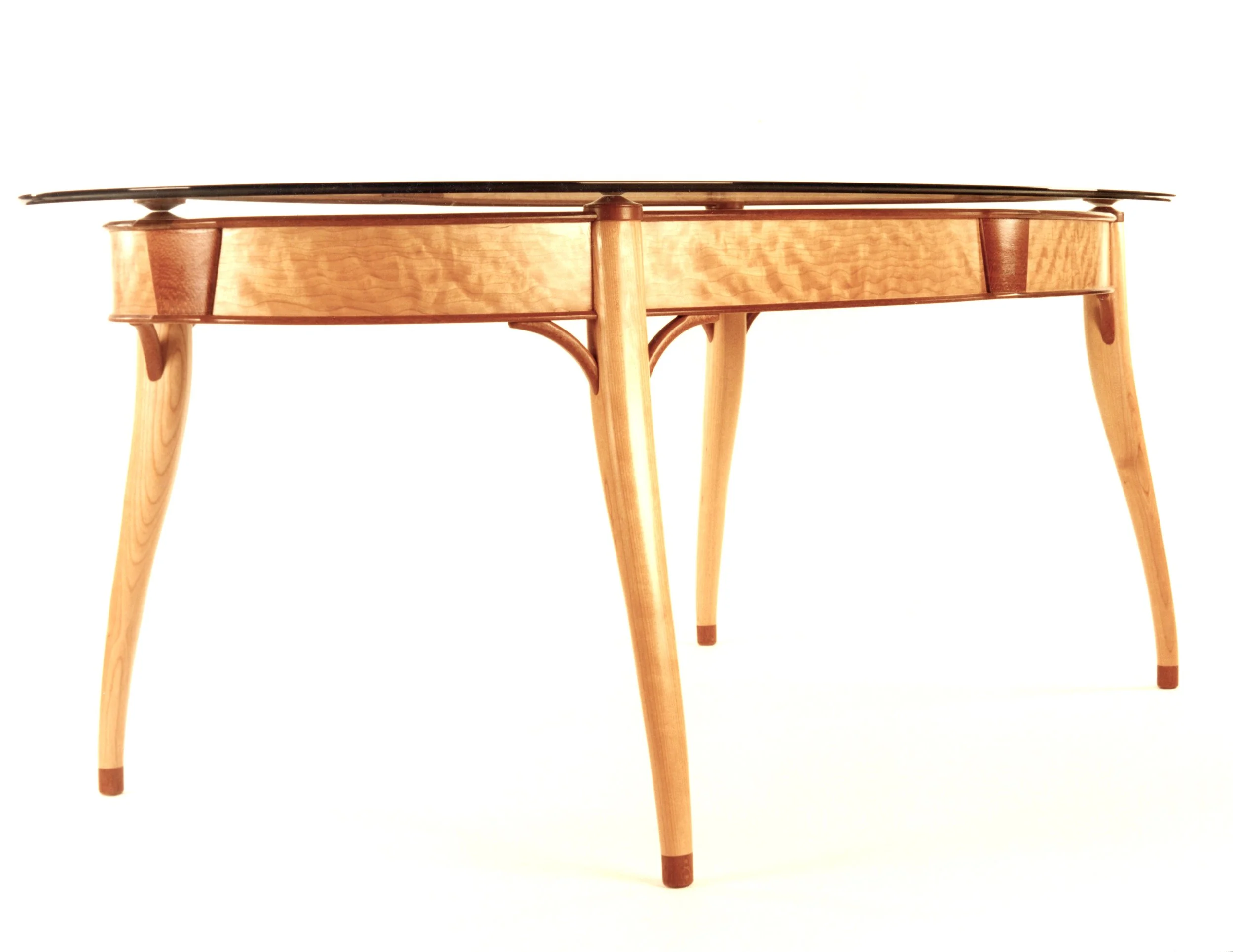 Wooden coffee table with glass top, curved legs, and decorative accents.