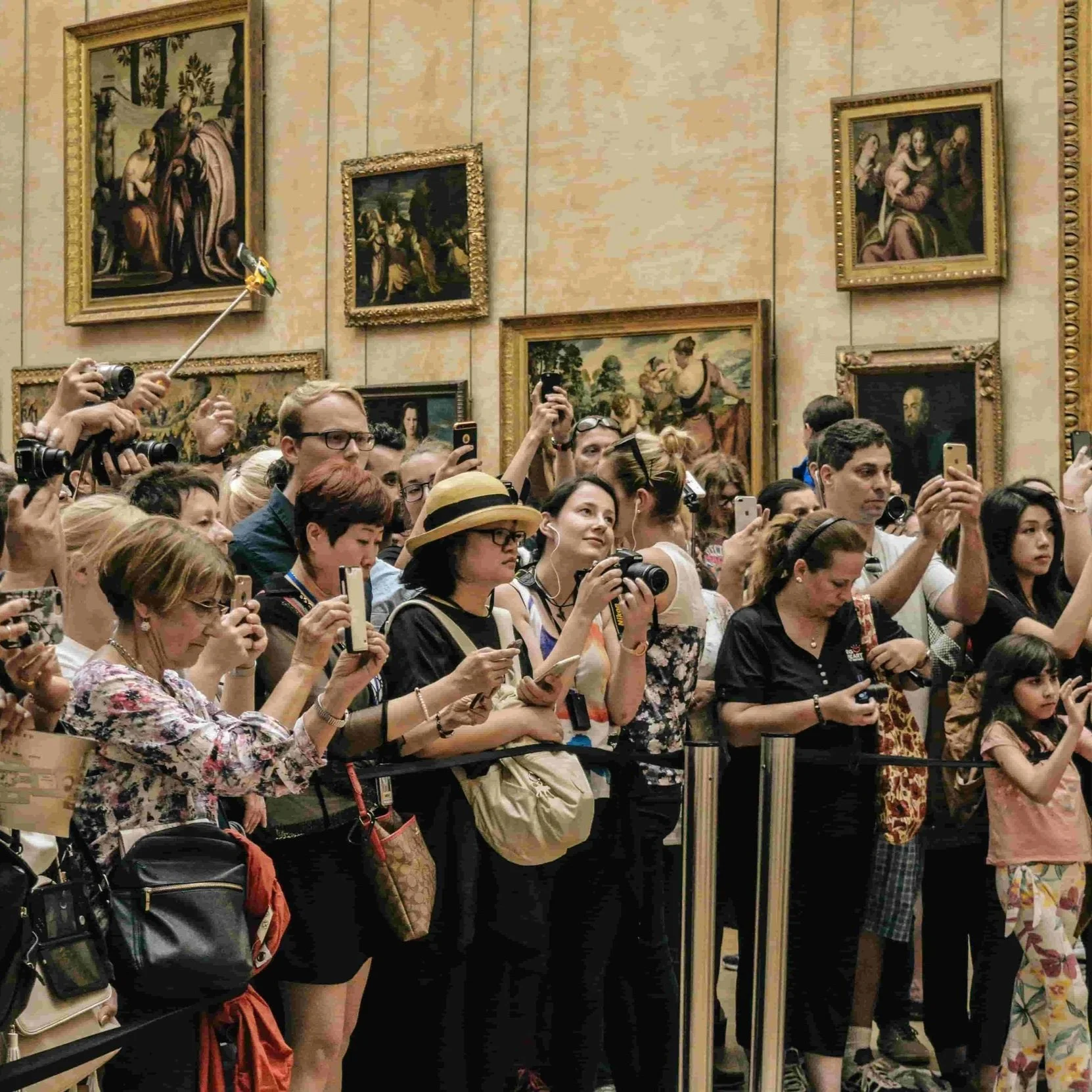 A crowd of tourists admiring the Mona Lisa at the Louvre.