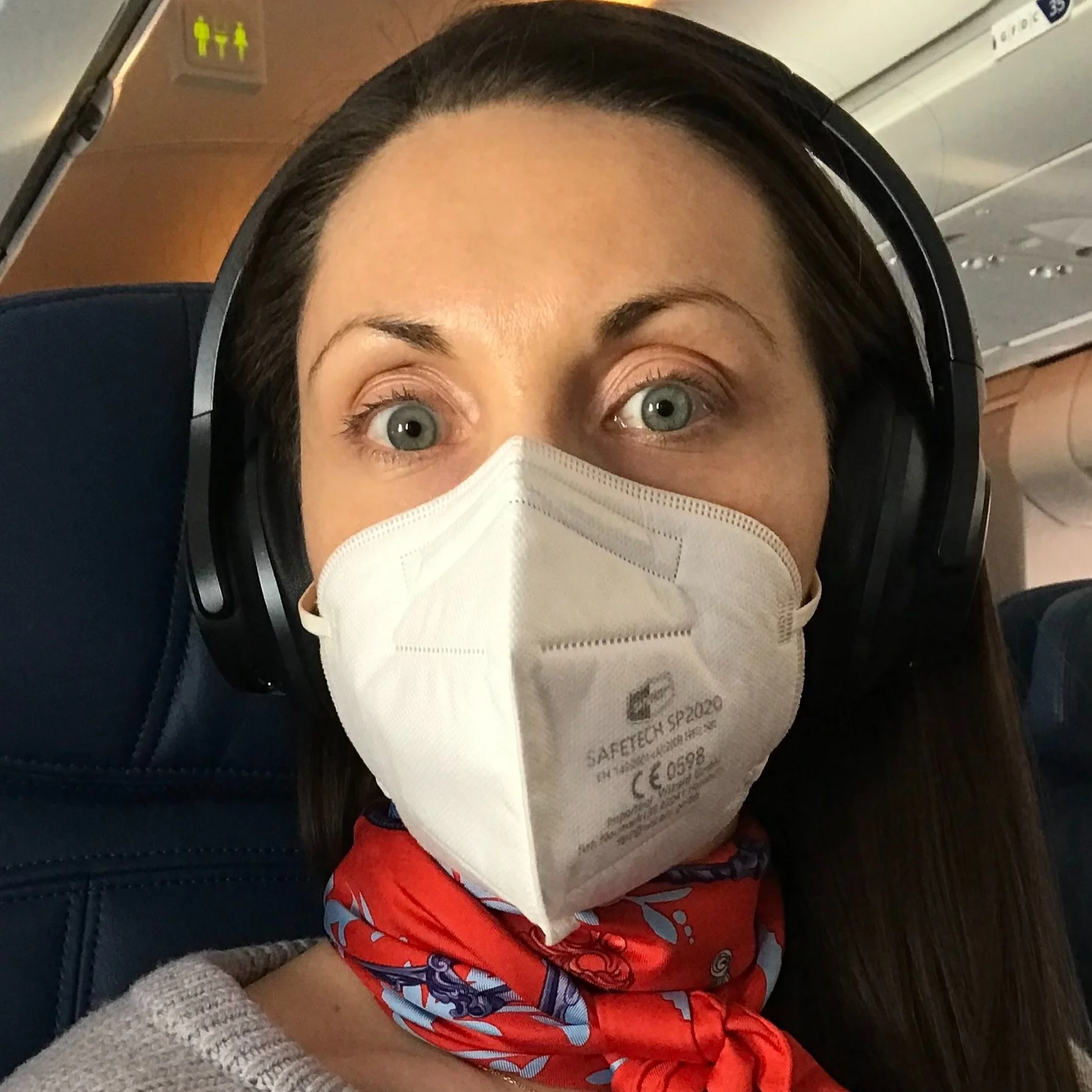 A selfie of the author wearing noise-cancelling headphones and a face mask.