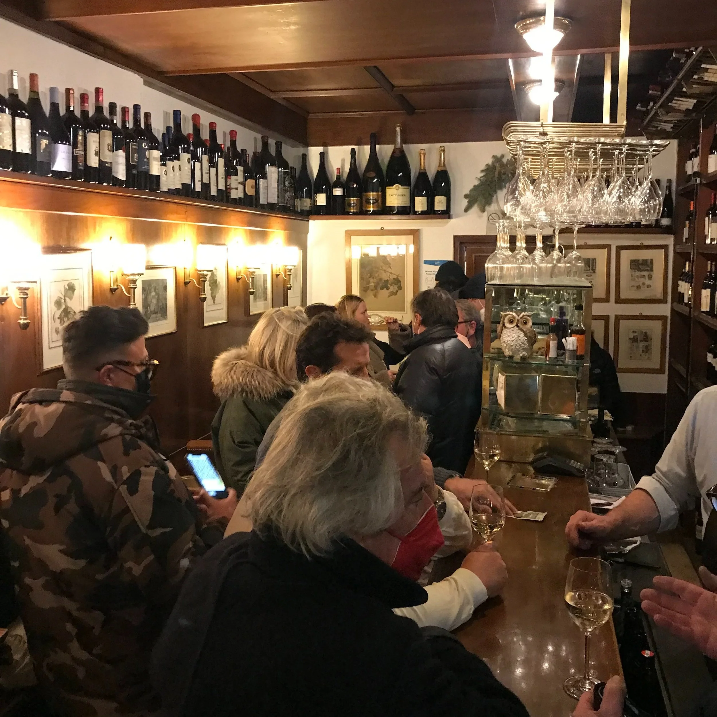 A crowd of patrons lines up to the bar at Enoteca Cortina.