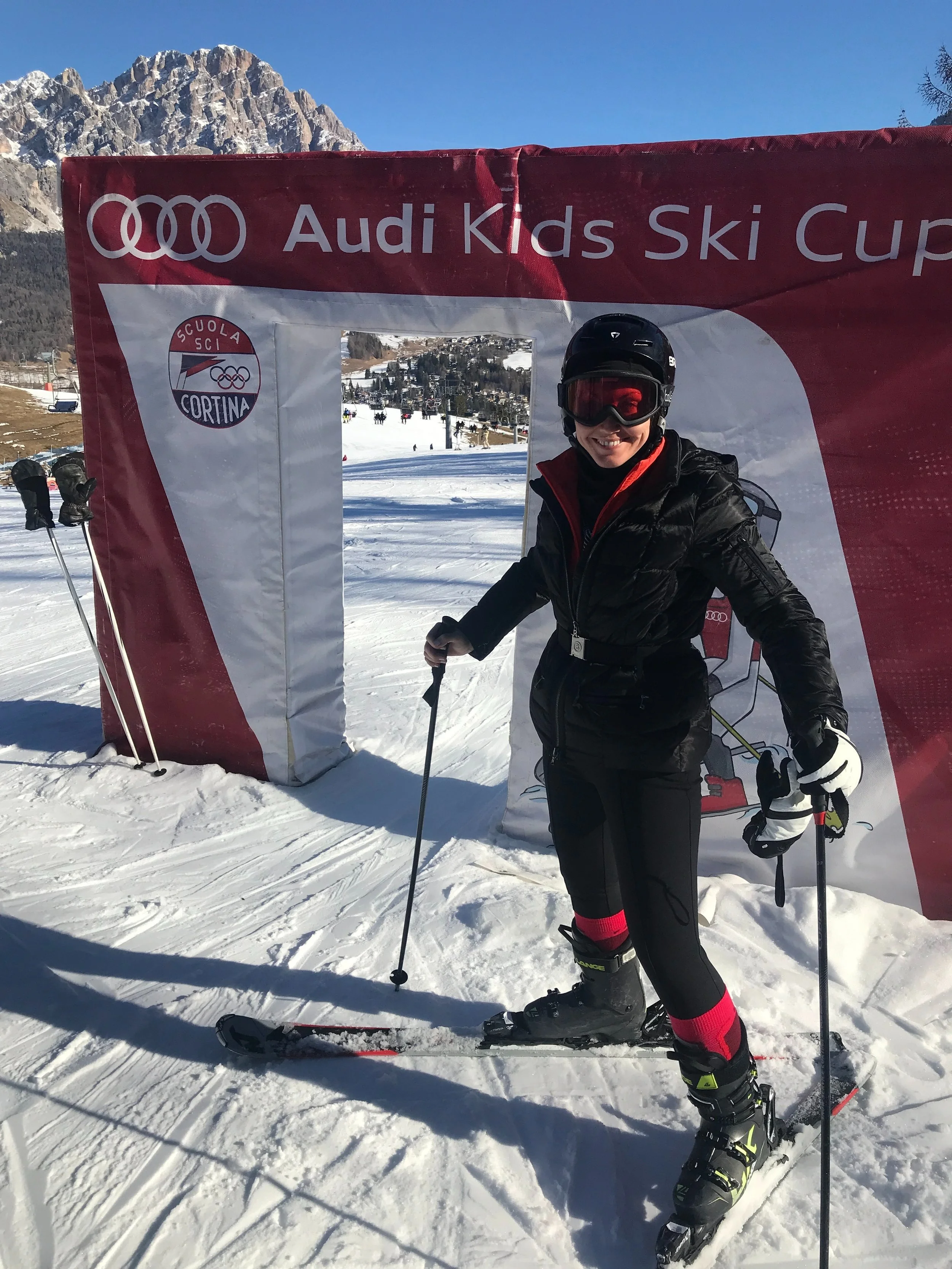 A skier in front of the "Audi Kids Ski Cup" sign.
