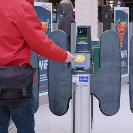 A person pays for entry to the London Tube with a contactless credit card payment.