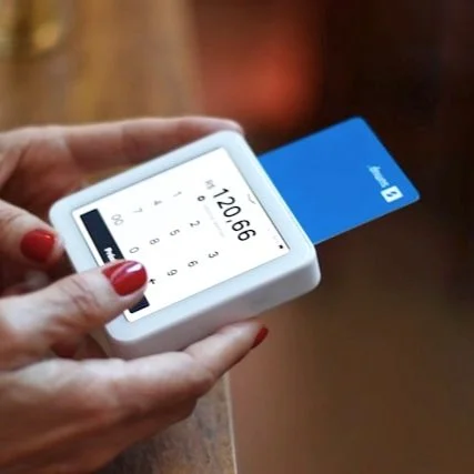 A woman pays for a purchase with a chip and pin card.