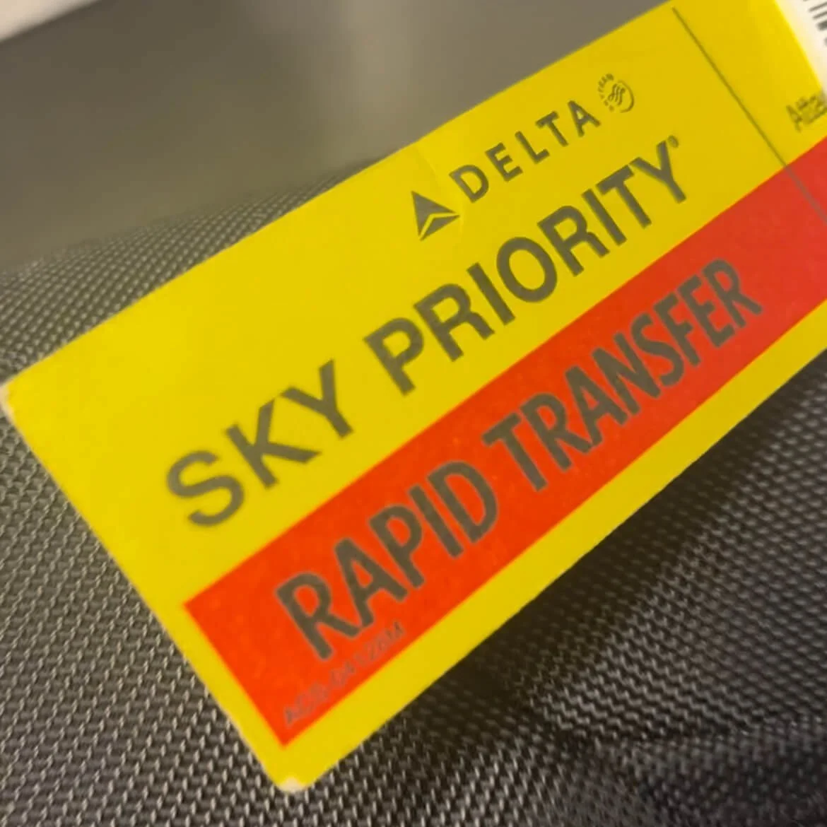 A Delta Air Lines rapid transfer luggage tag on a piece of luggage.