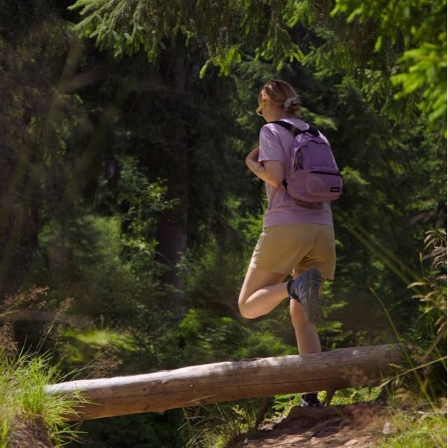 A hiker wearing a small backpack on a trail.
