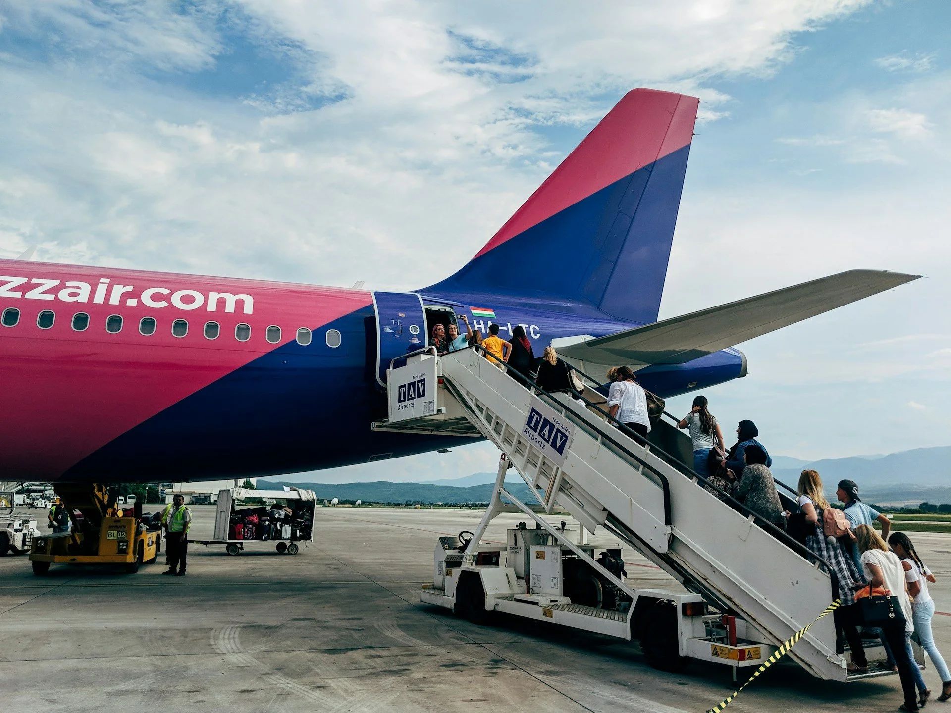 Passengers boarding the rear of a plane from the tarmac.