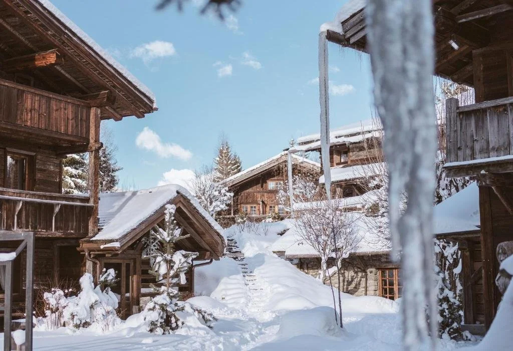 The assembled buildings of Les Fermes de Marie sitting under deep snow.