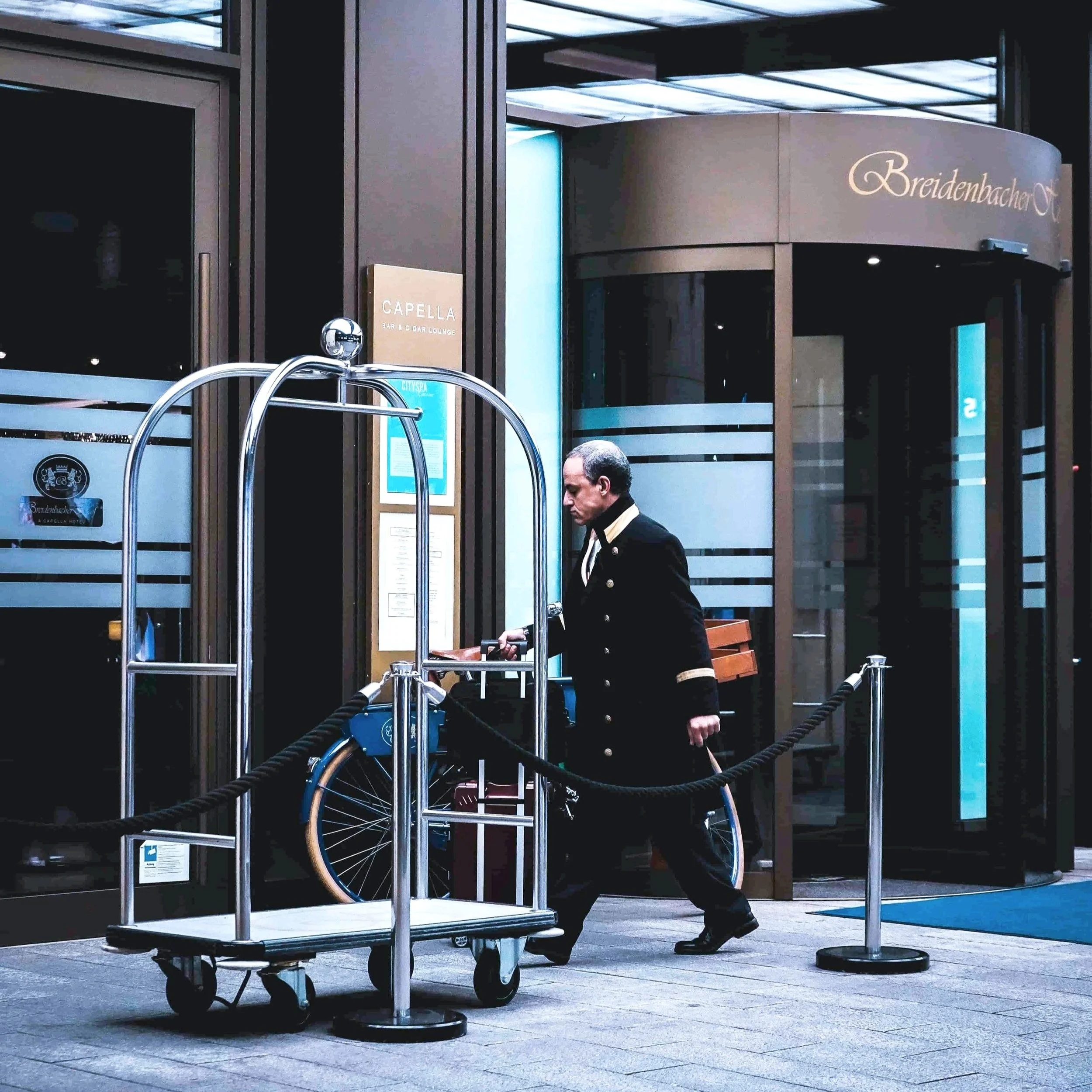 A hotel bellman with an empty luggage rack.