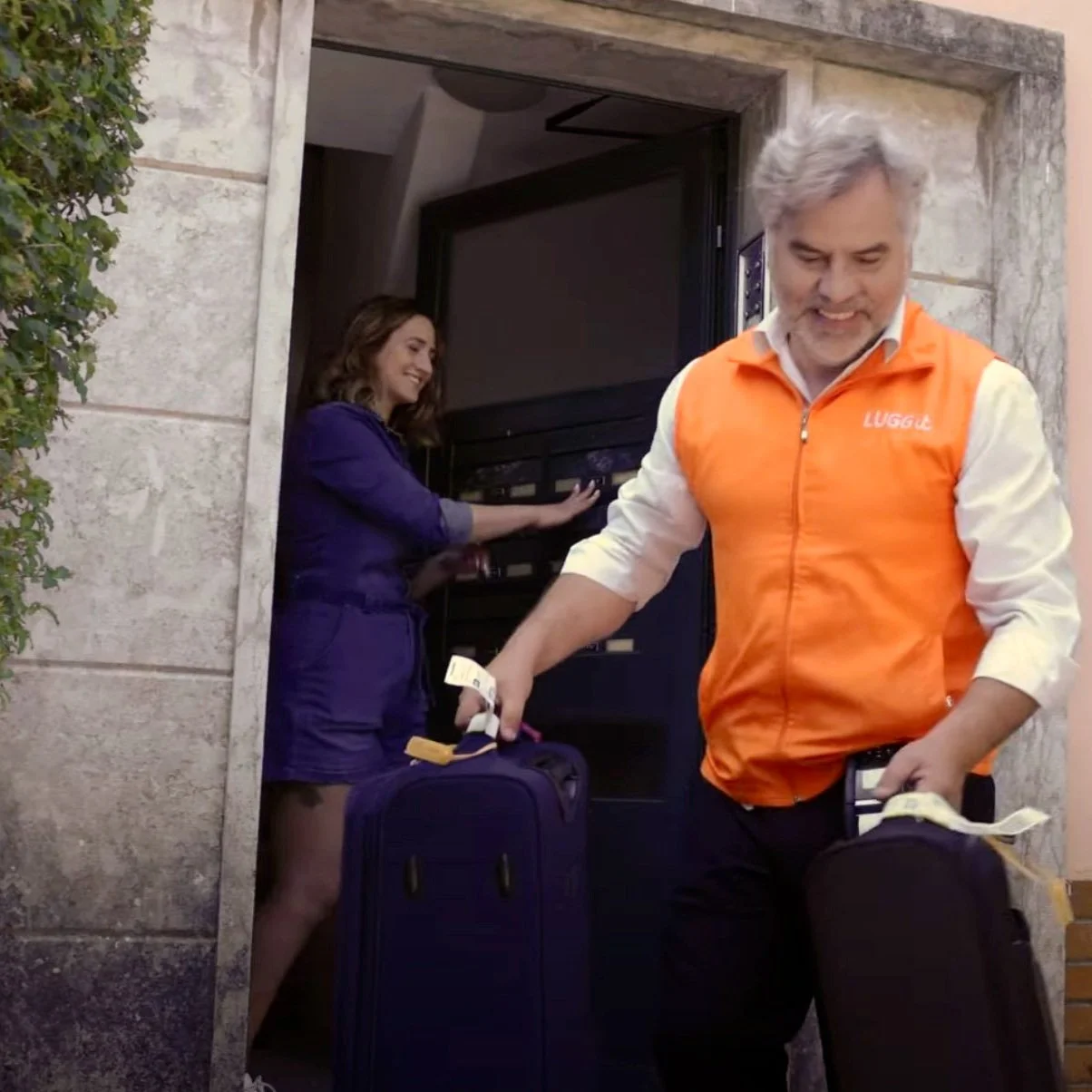 A member of the LUGGit team picking up luggage from a traveler.