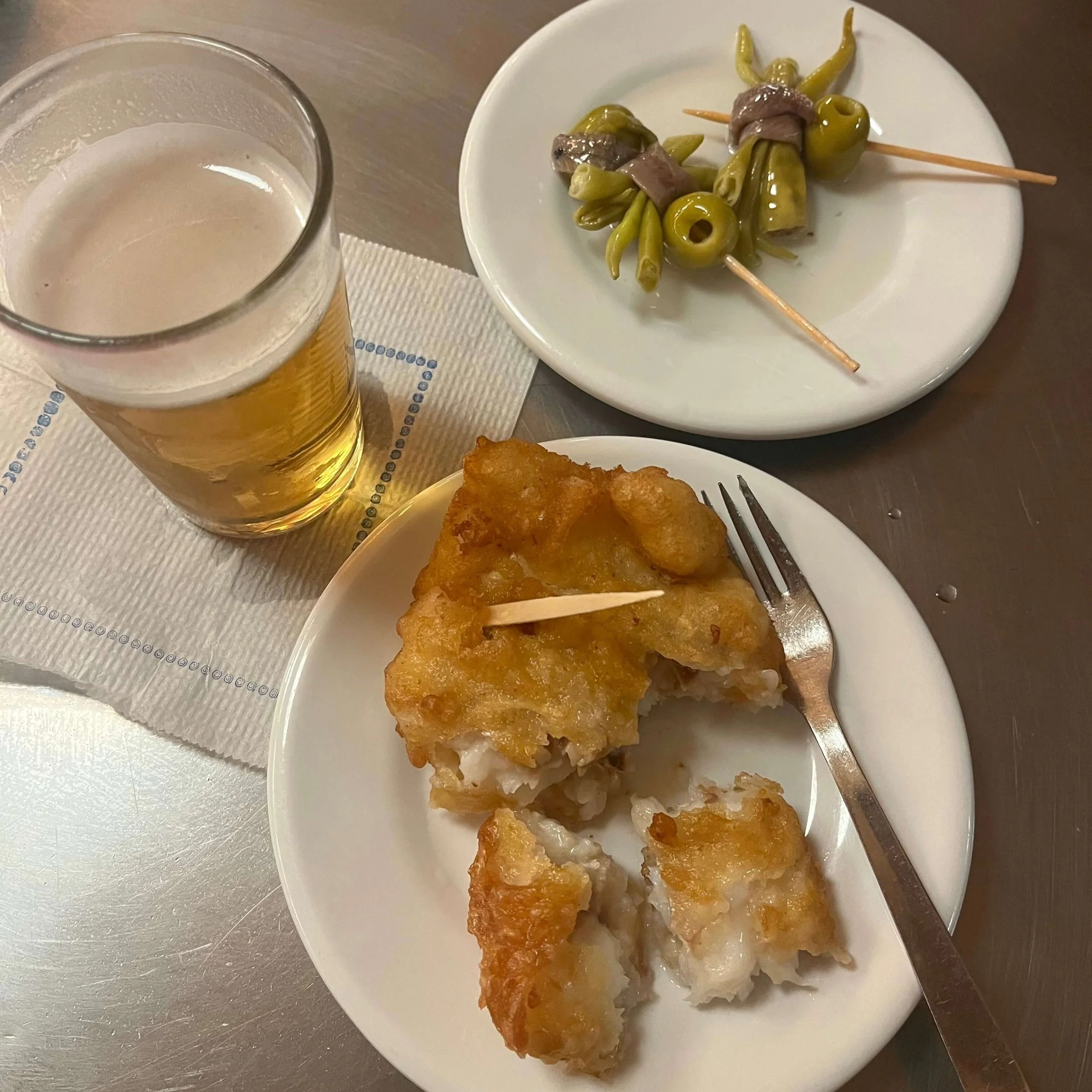 Beer and tapas of fried cod and gilda pintxos.