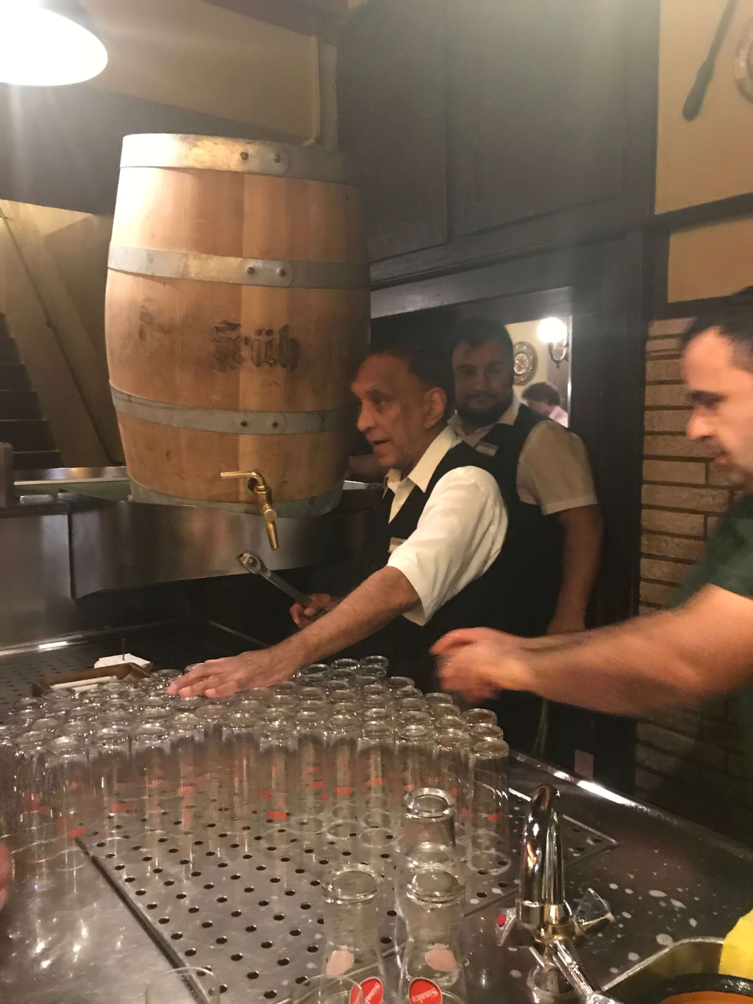 Kölsch being served out of a wooden keg.