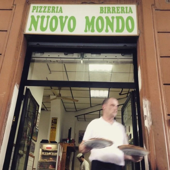 A server carries a pizza to the terrace at Pizzeria Nuovo Mondo in Rome.