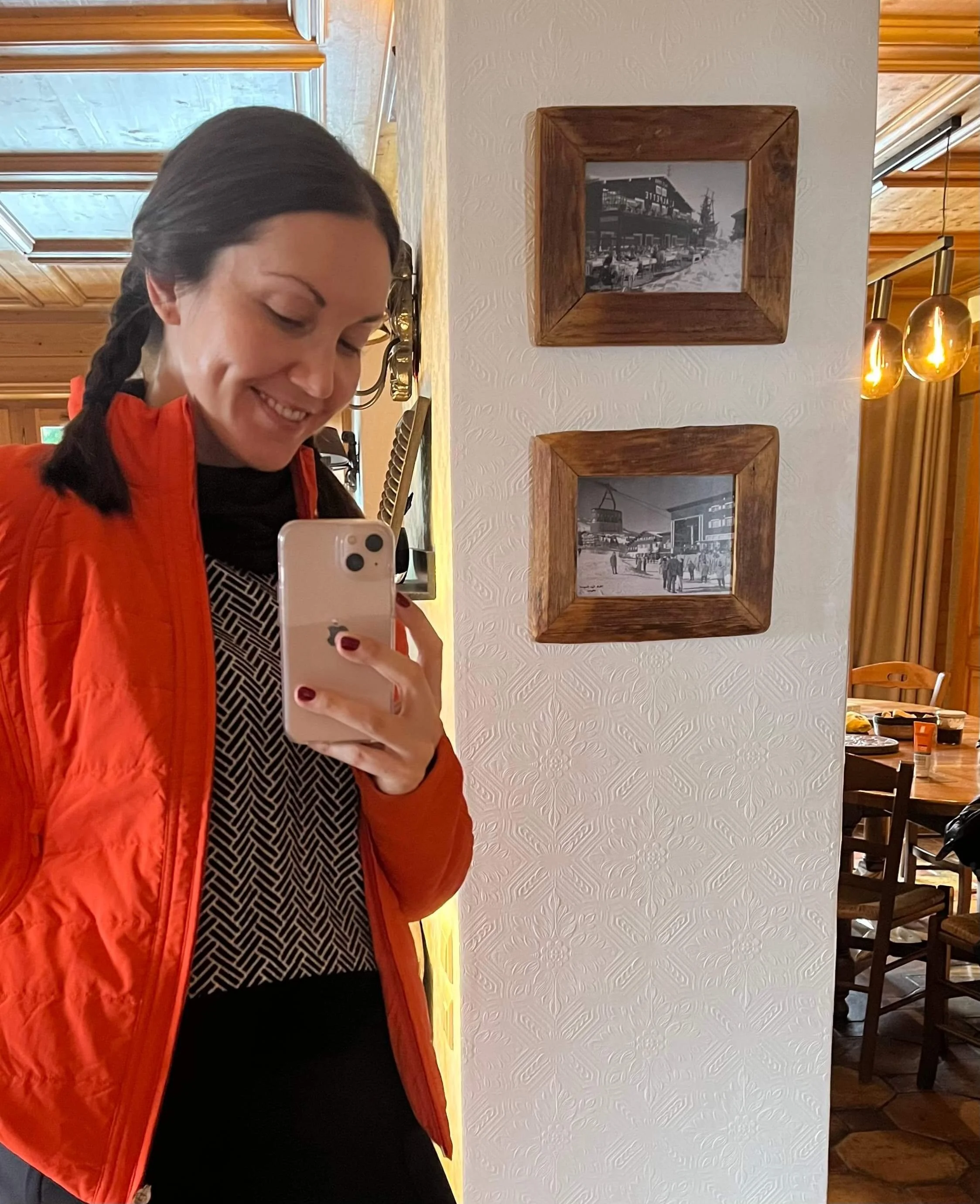 A skier shows off their mid-layers and other pieces to pack for a ski trip.