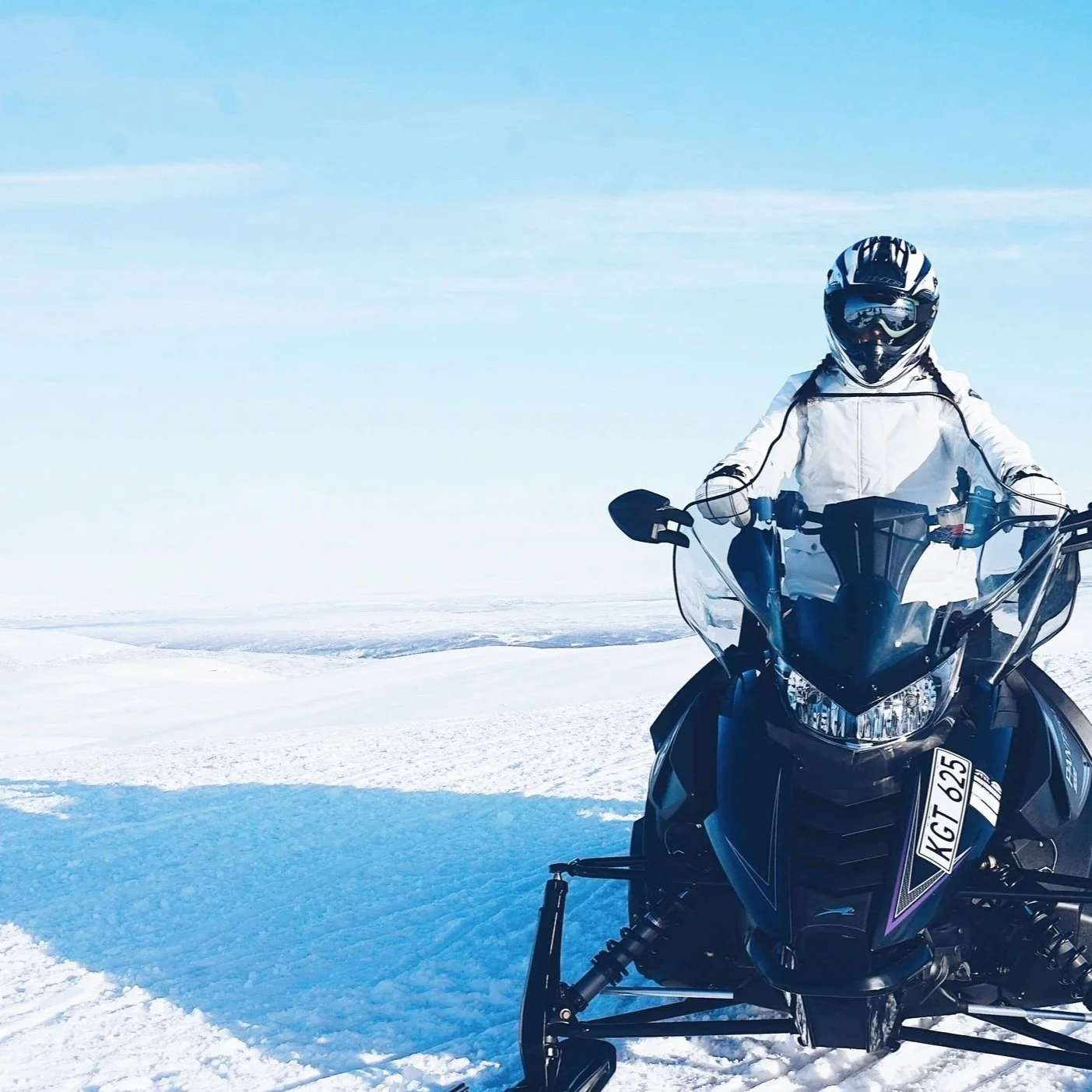A person sitting atop a snowmobile.