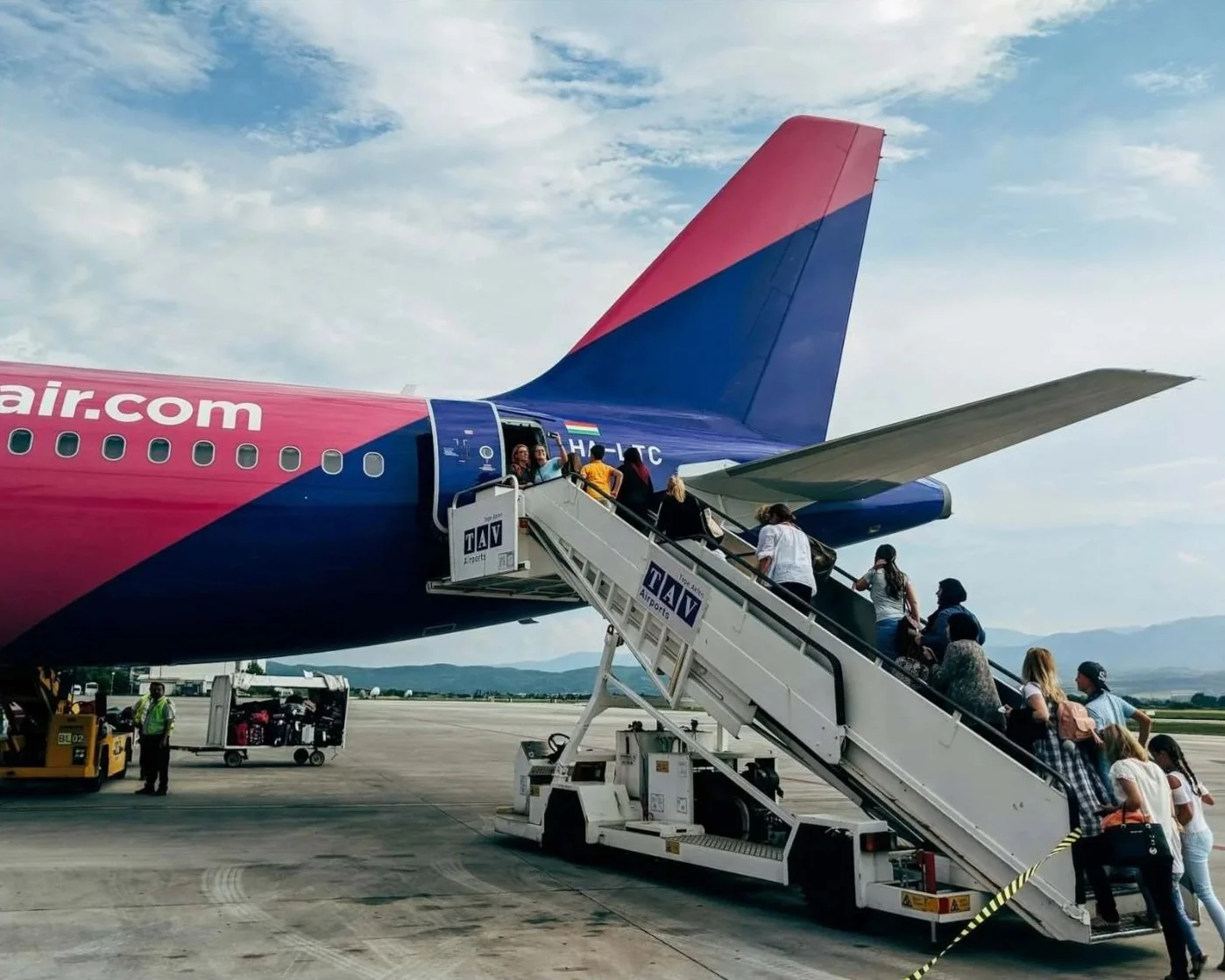 Travelers boarding the rear of an airplane on the tarmac.