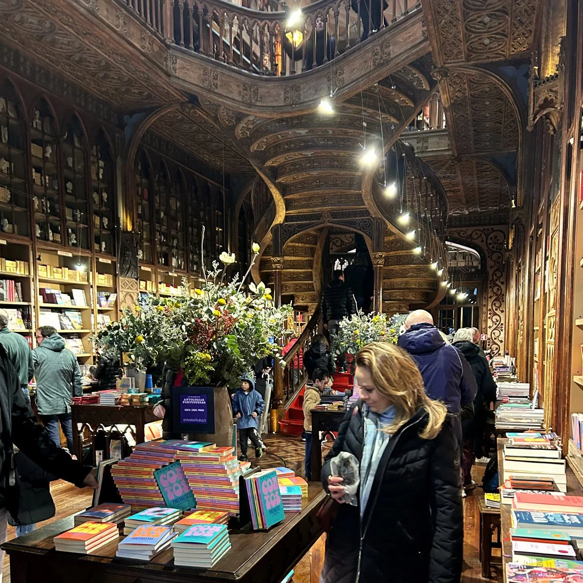 The interior of Livraria Lello, with book displays and crowds of visitors.