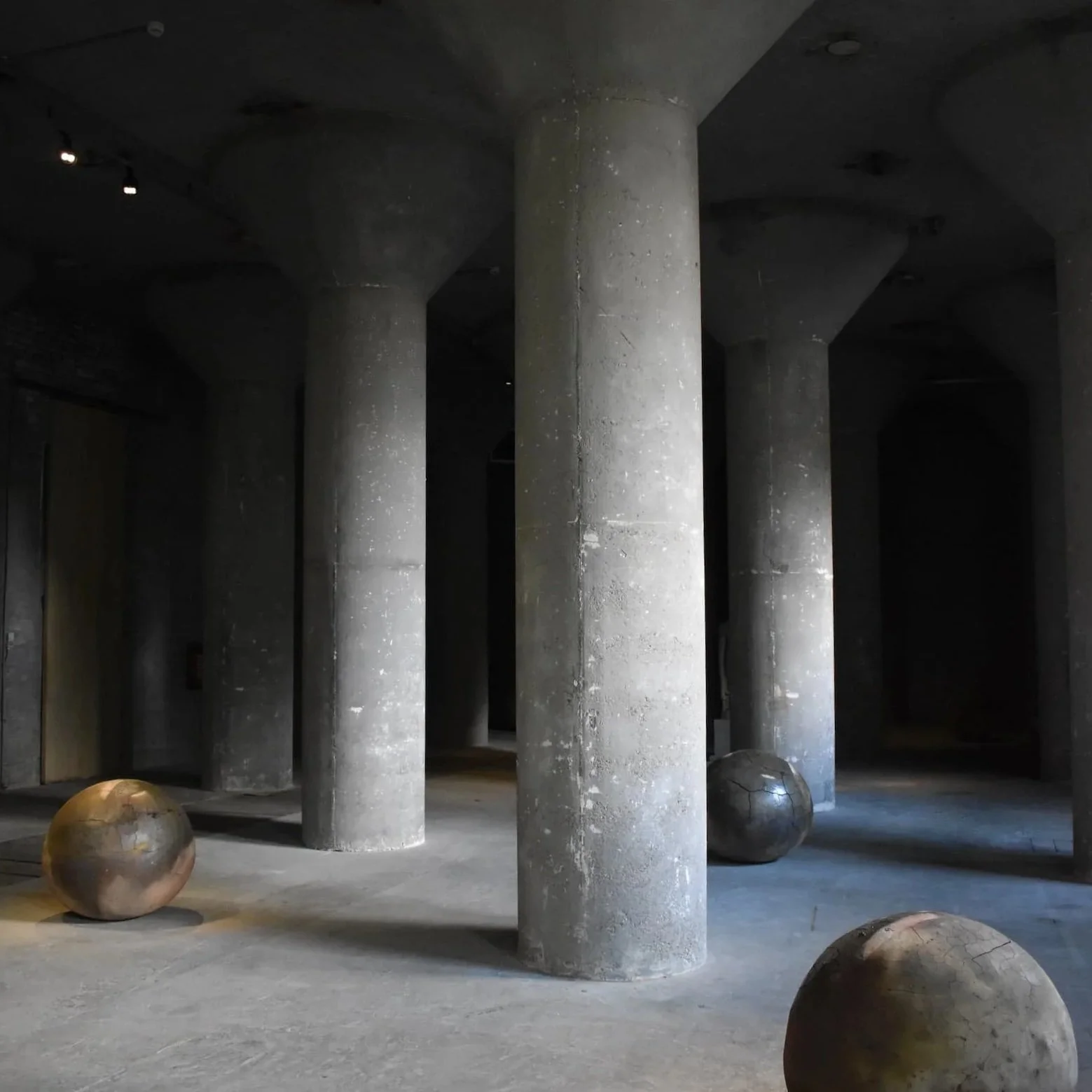 A stark display at Axel Vervoordt Gallery, with concrete columns and round orbs.