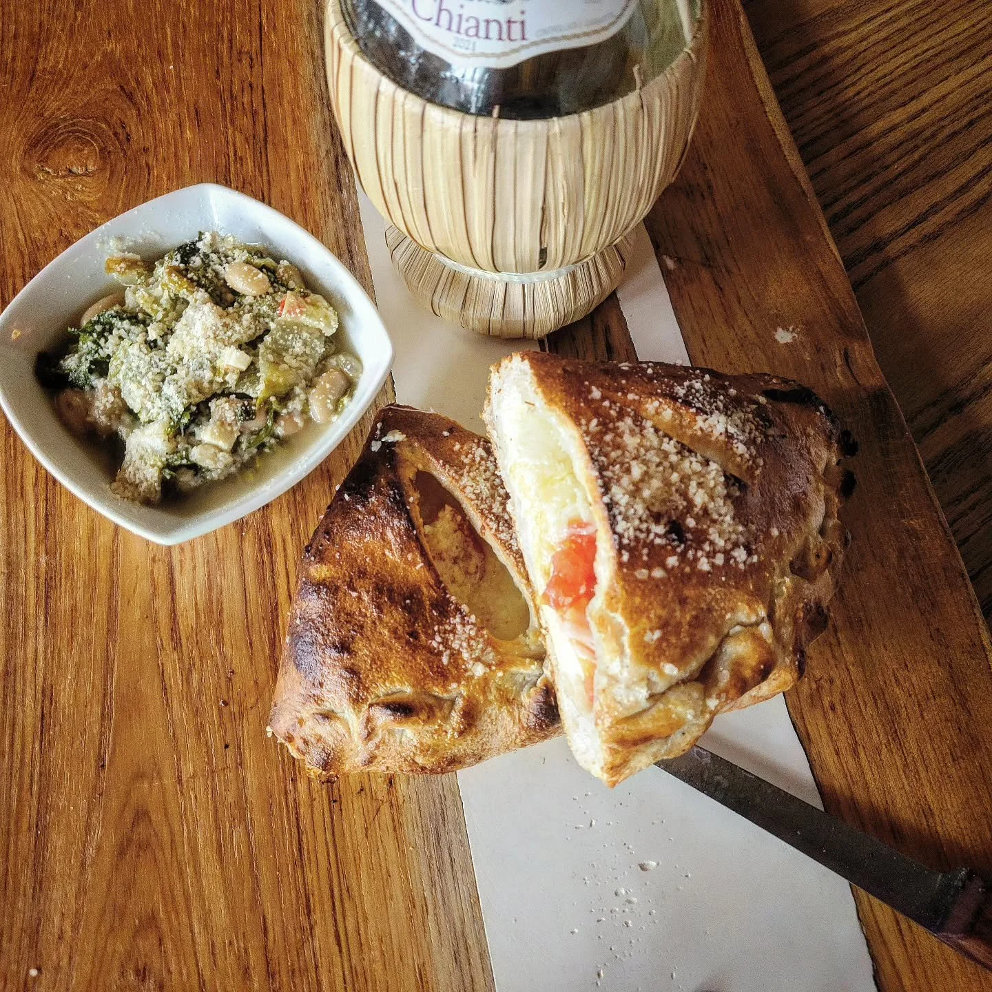 Beans and Greens calzone tonight! We slowly cooked garlic and Fresno chilies with ham hocks and chicken stock, stirred in a bunch of escarole and cannellini beans and simmered it a little while longer until everything came together. Served with a cal