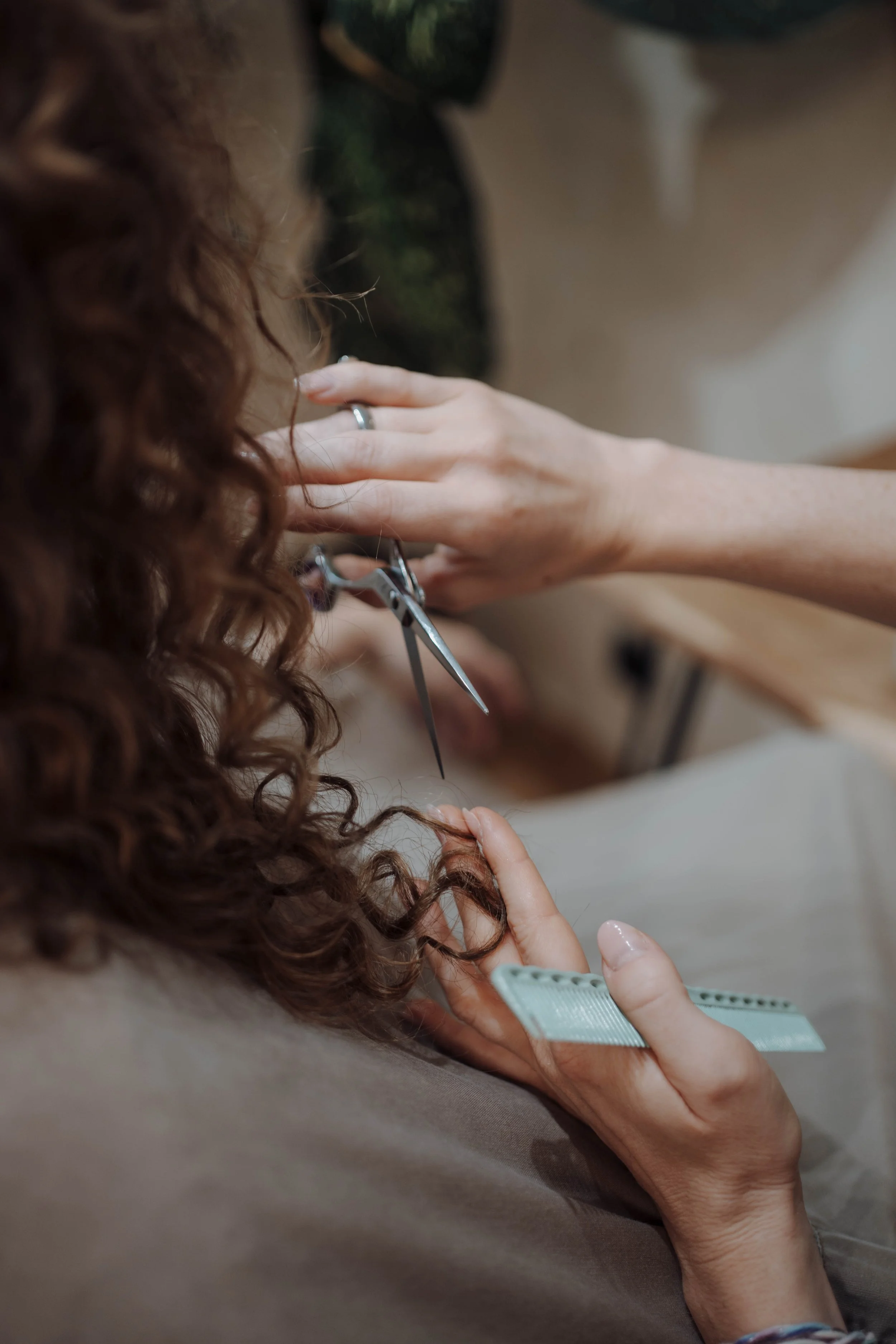 Person schneidet die Haare einer anderen Person mit Friseurschere.