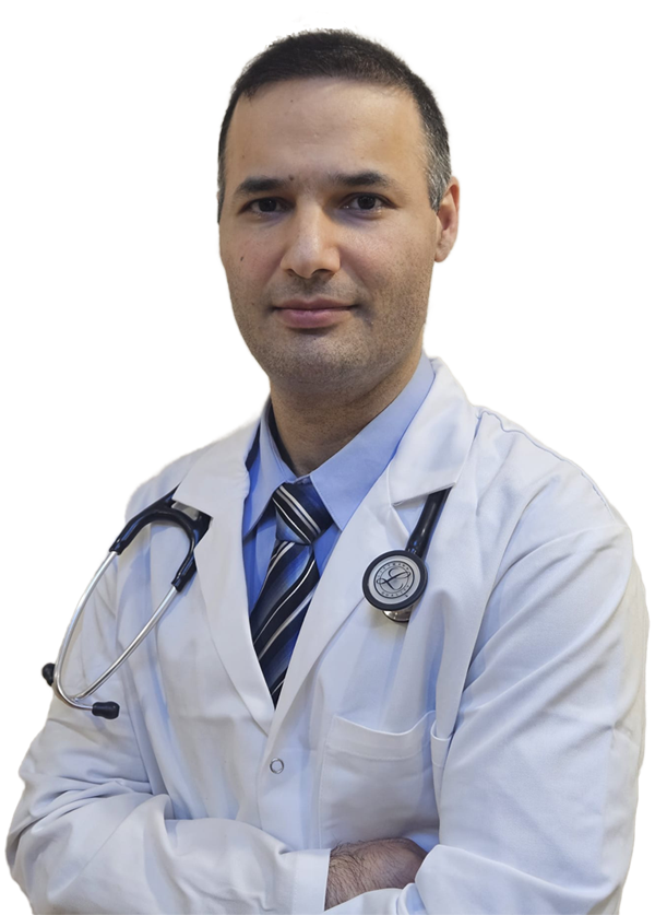 A male doctor wearing a white lab coat and a stethoscope around his neck, standing with arms crossed and looking at the camera.