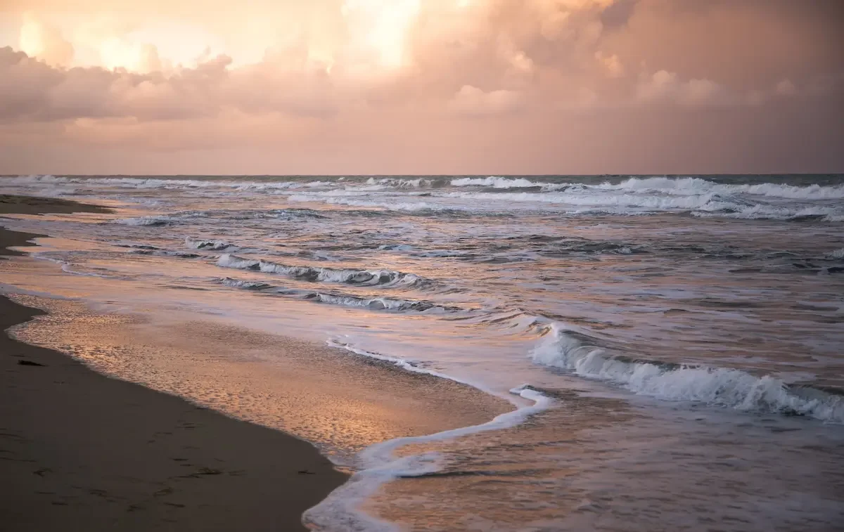 Waves washing ashore at sunset on Whitecap Beach, Corpus Christi, Texas