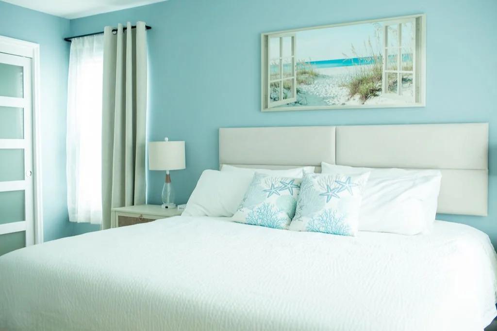 King master bedroom at The Oasis vacation rental in Corpus Christi TX, with coastal decor, white bedding, and teal walls