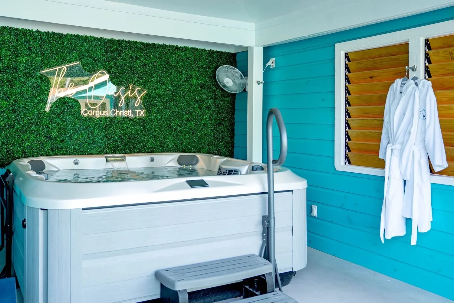 Hot tub room with The Oasis branding and folded guest robes in Corpus Christi