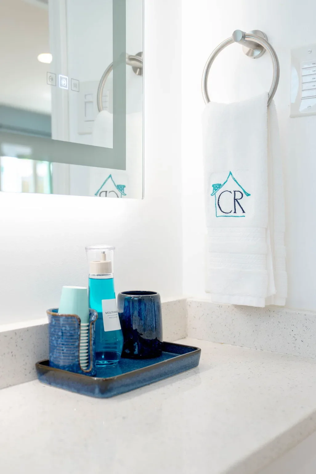 Bathroom amenities tray with a monogrammed towel at The Oasis vacation rental
