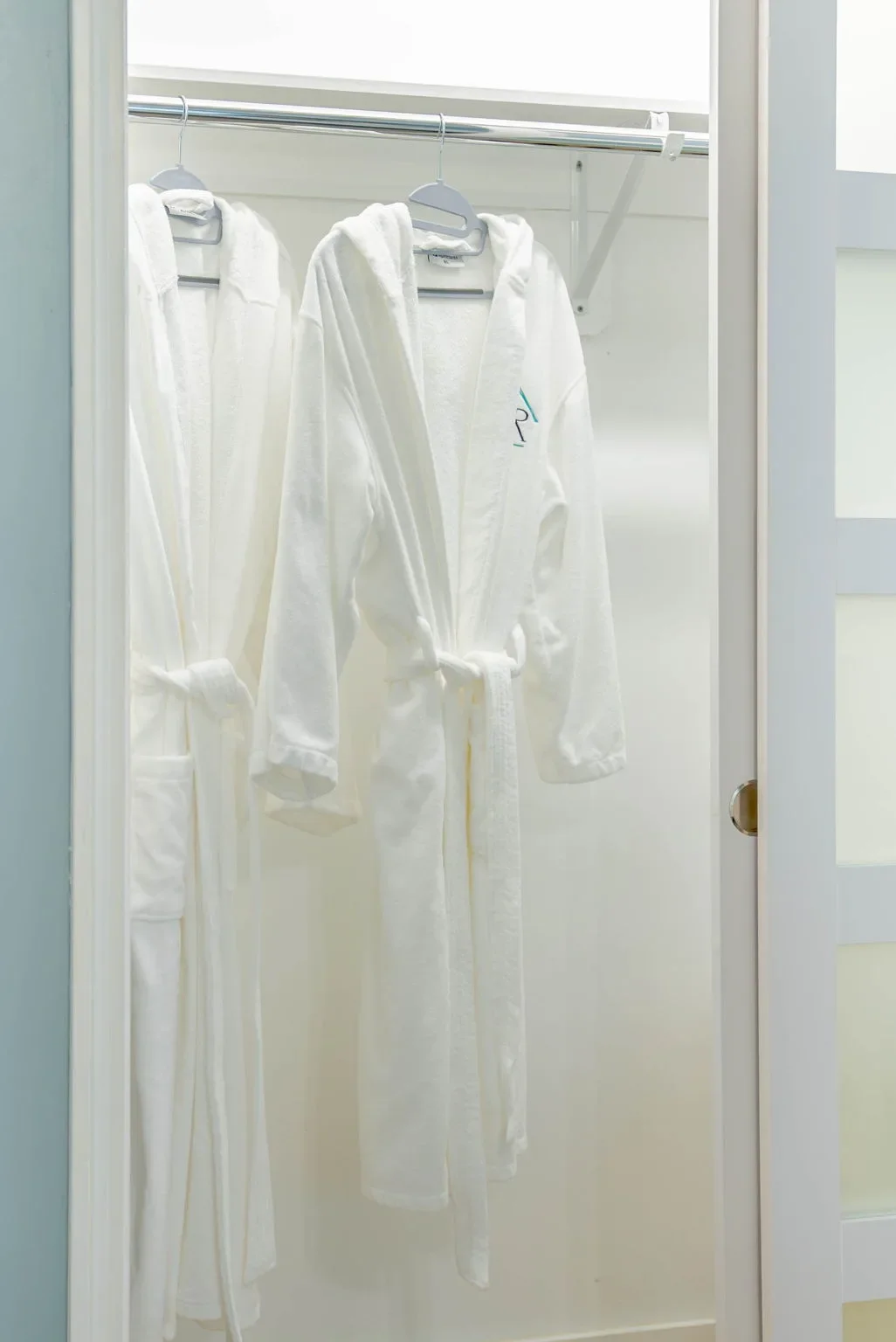 White guest robes hanging in the closet at this Corpus Christi vacation rental