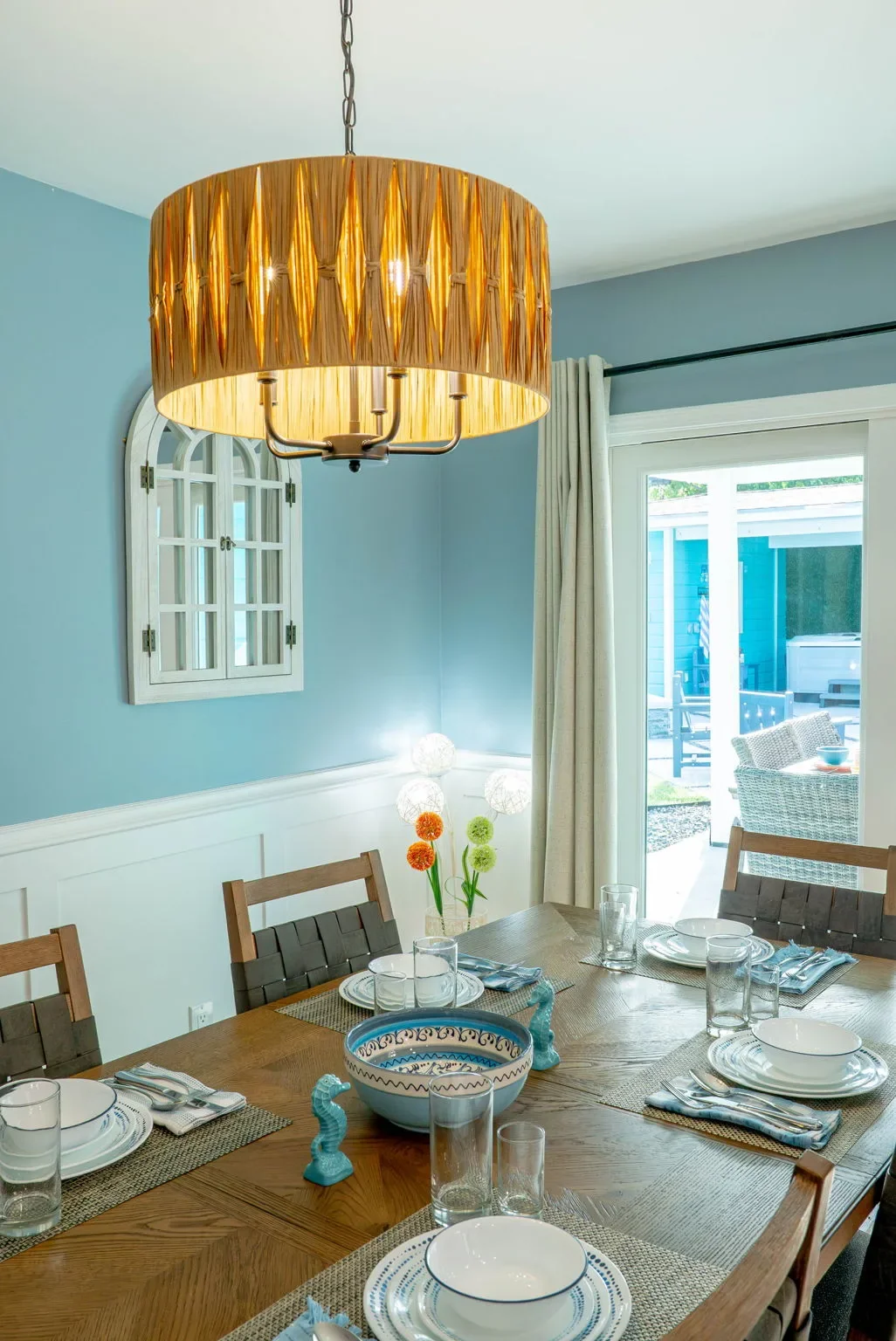 Dining table set for guests with a pendant light above at The Oasis