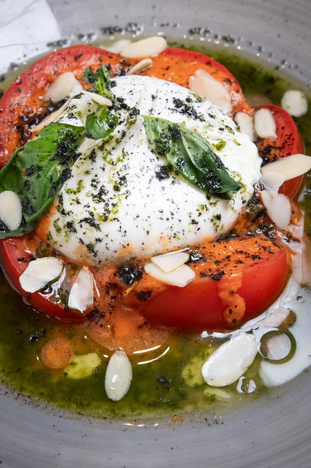 Burrata con tomate de la huerta valenciana y albahaca fresca y especias.