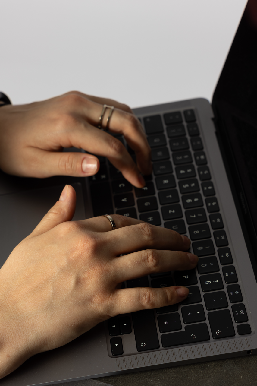 Zwei Hände tippen auf einer Laptop-Tastatur.