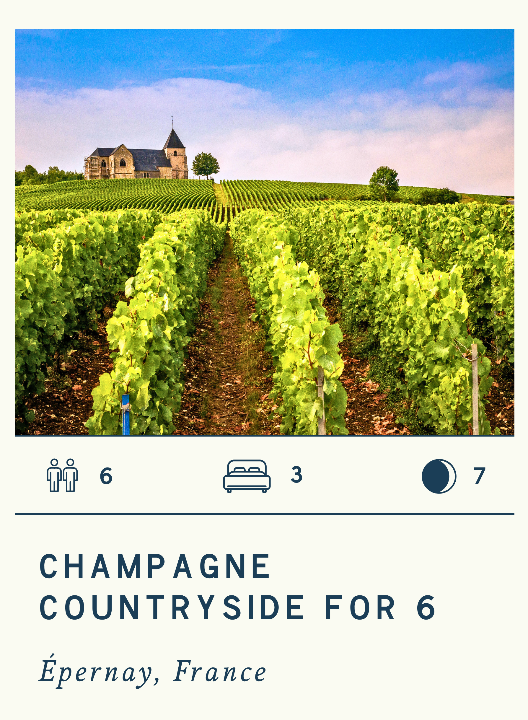 Vineyard with rows of grapevines leading to a stone church on a hilltop in Épernay, France, under a blue sky