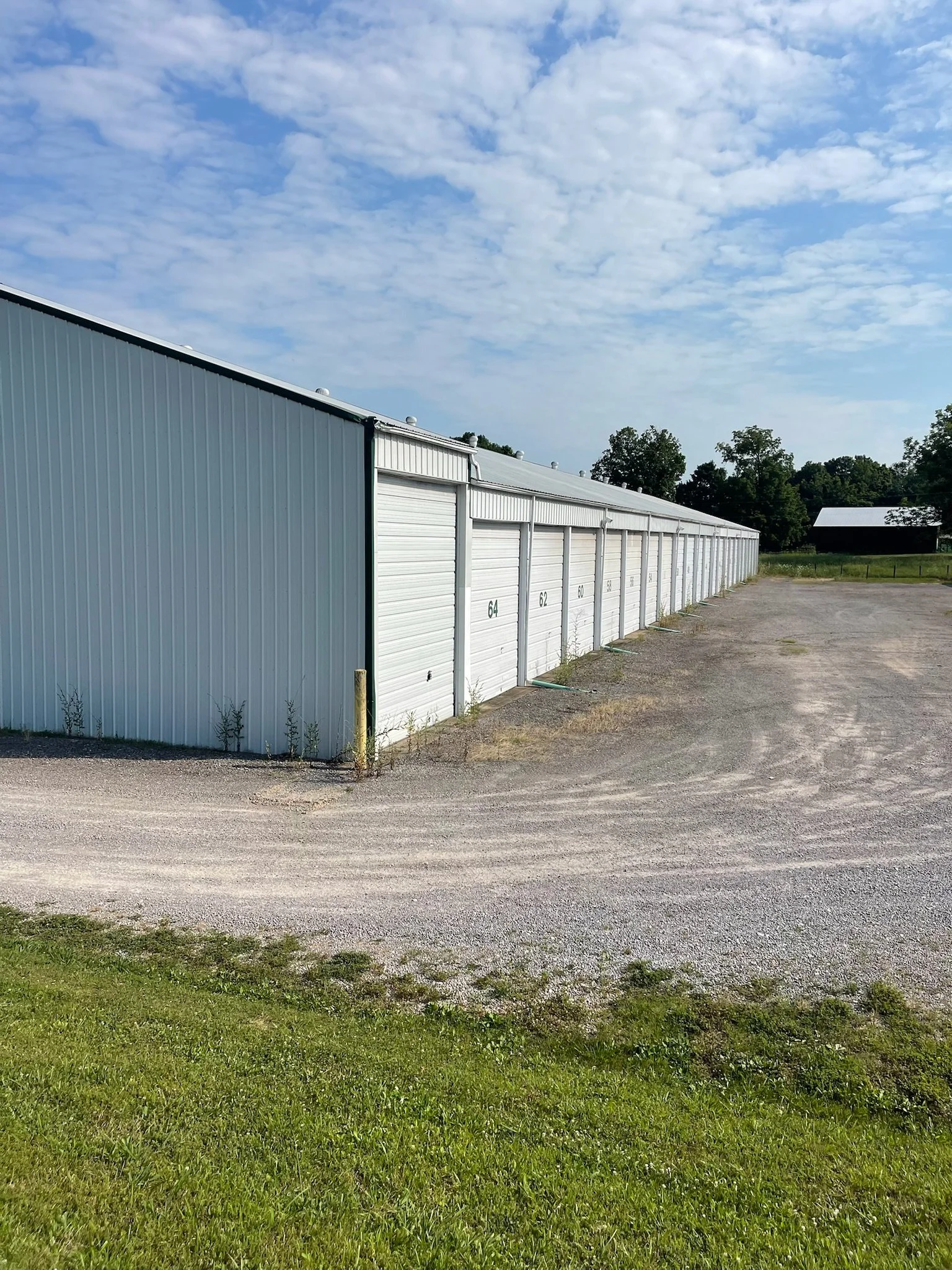 A row of white storage unit garages with closed doors.