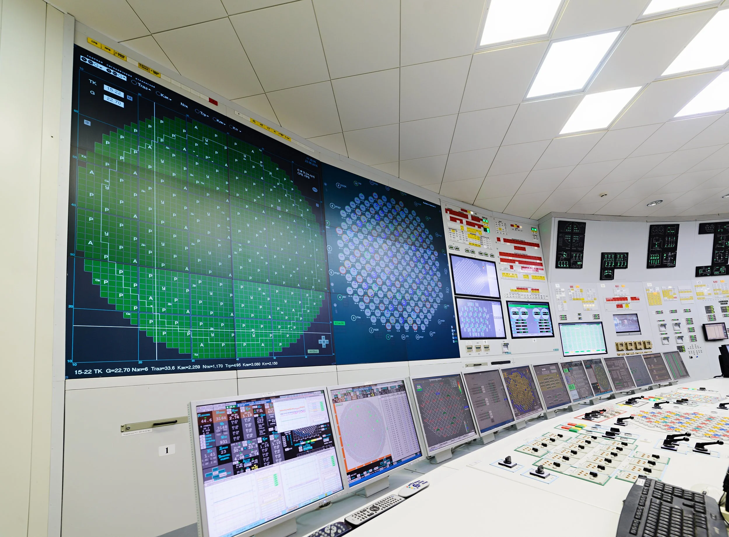 A control room with multiple monitors displaying data, graphs, and diagrams related to a nuclear power plant's operations.