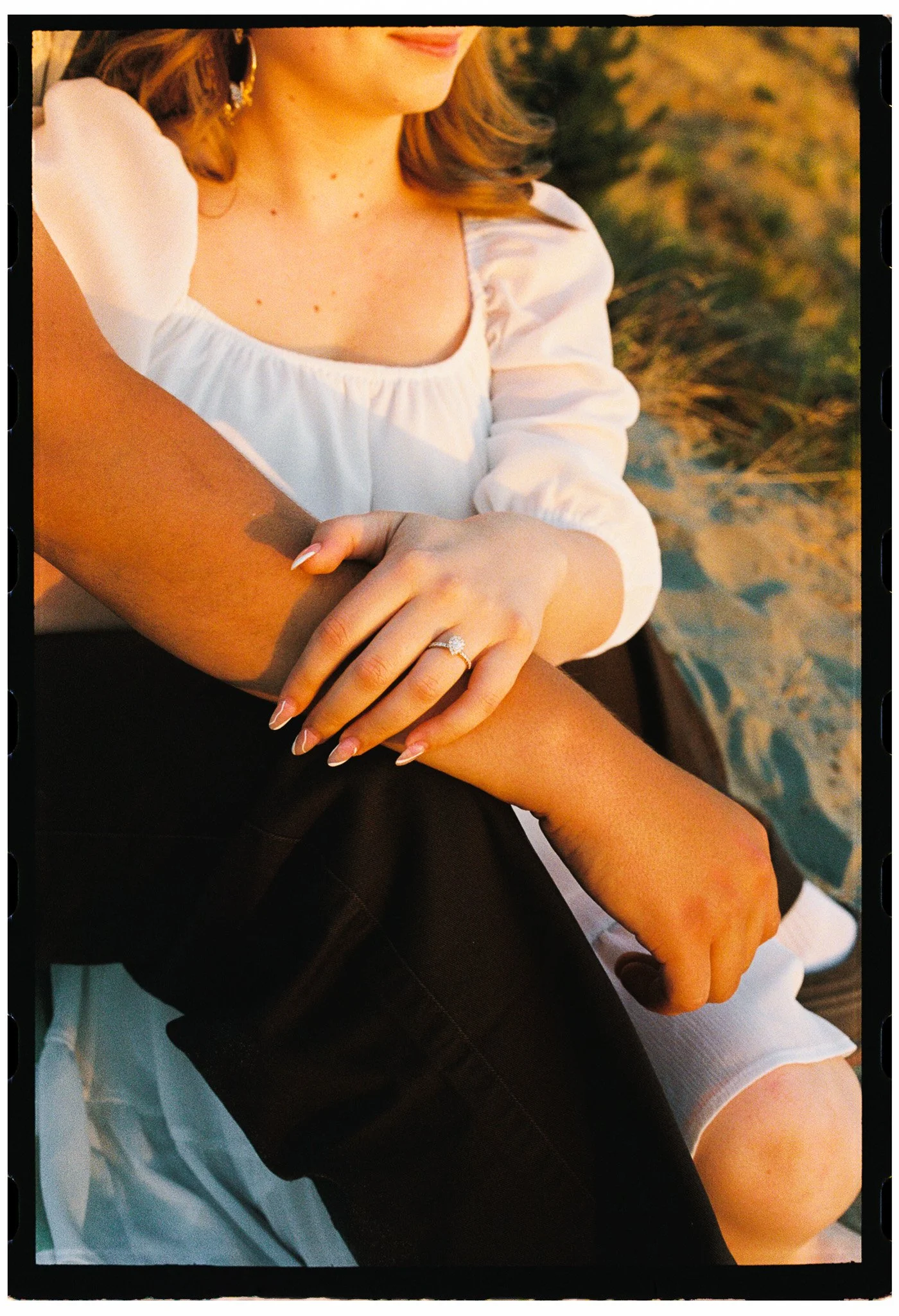 Close-up engagement portrait of a woman's hand with an engagement ring at Discovery Park, Seattle, Washington