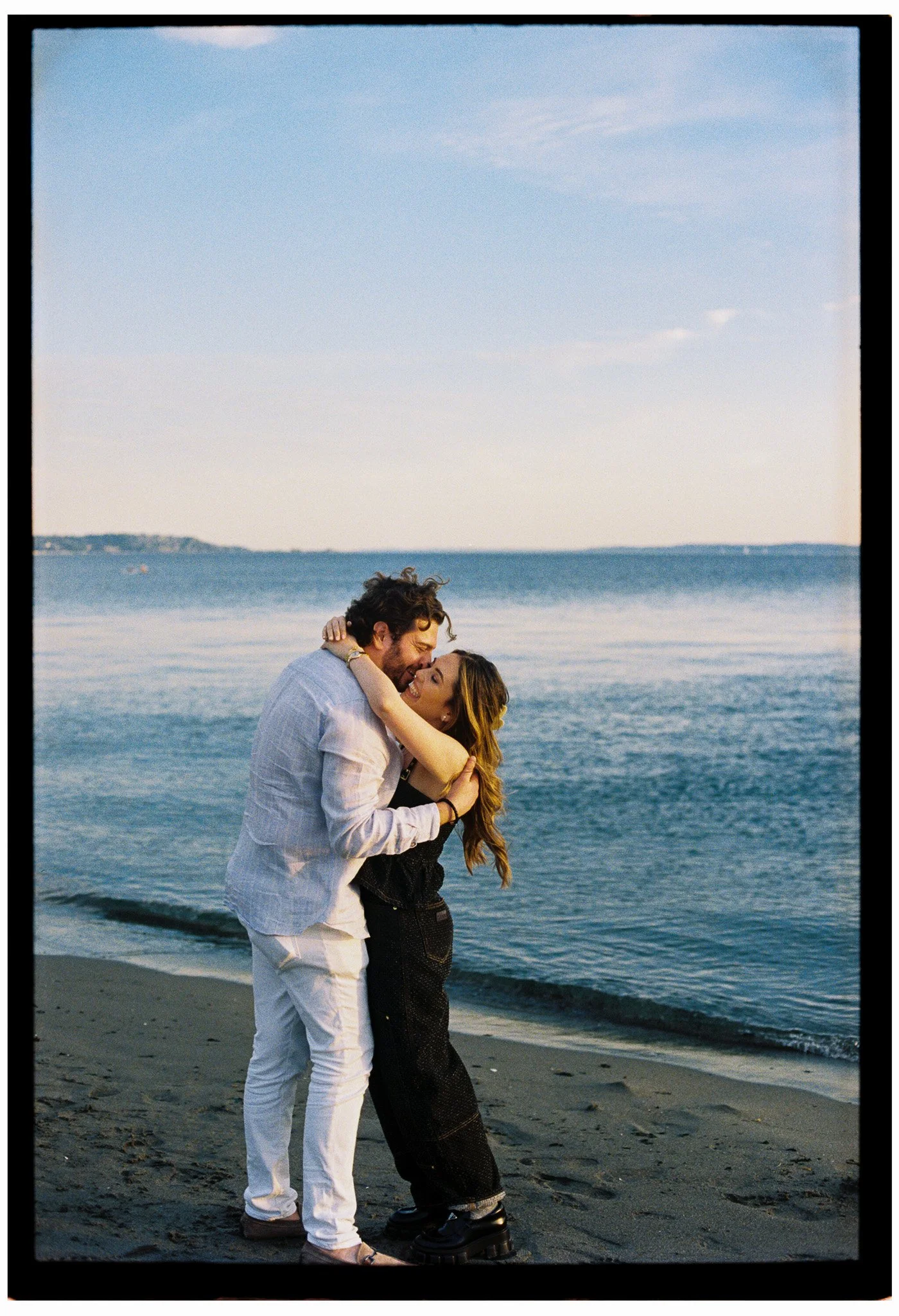 A couple embracing each other for an engagement shoot at Discovery Park in Seattle, Washington