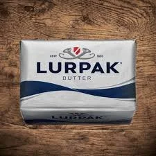 A package of Lurpak butter on a wooden surface.