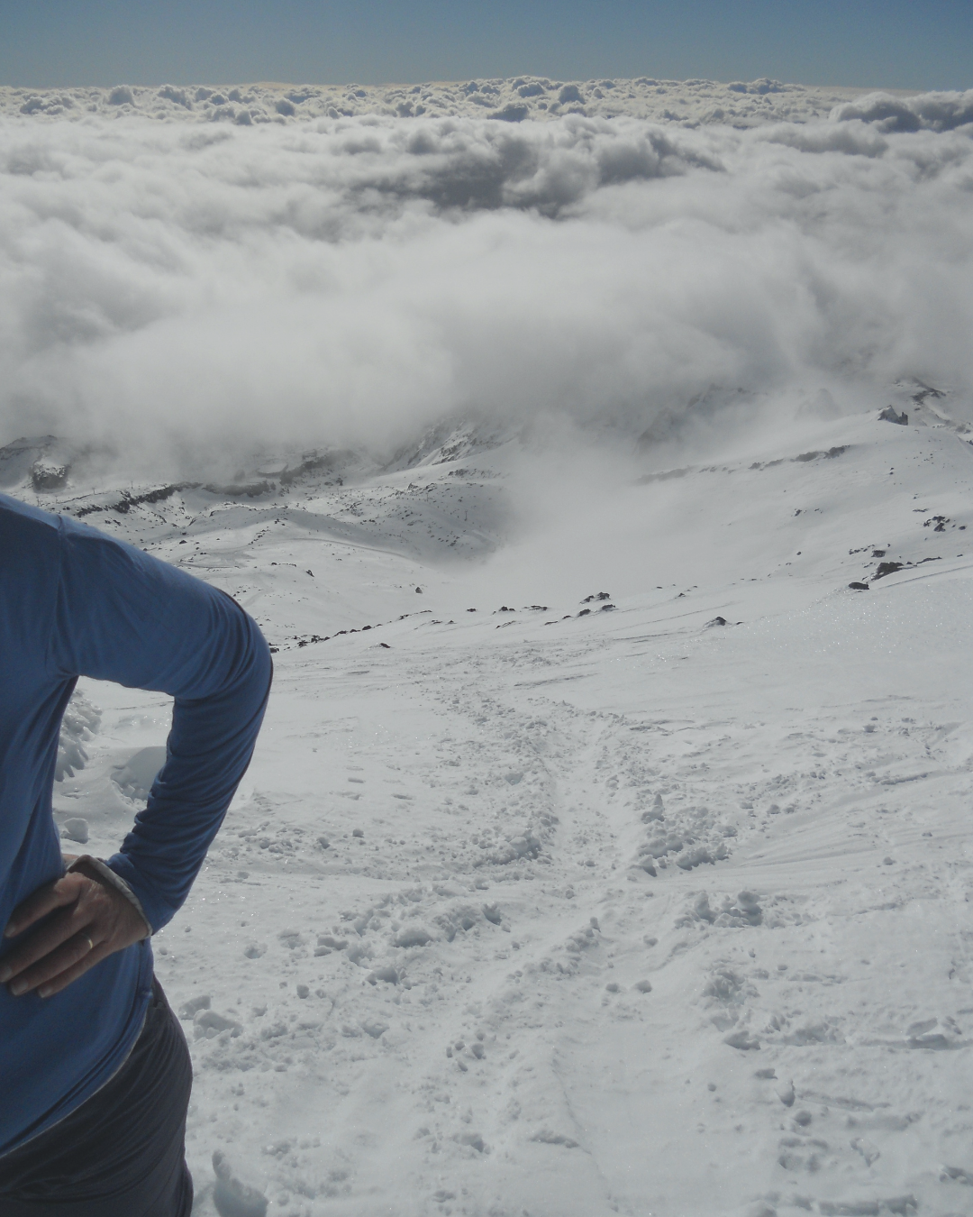 _A woman standing on a mountain summit under a muted sky, capturing the feeling of deep emotion, reflection, and inner transition._