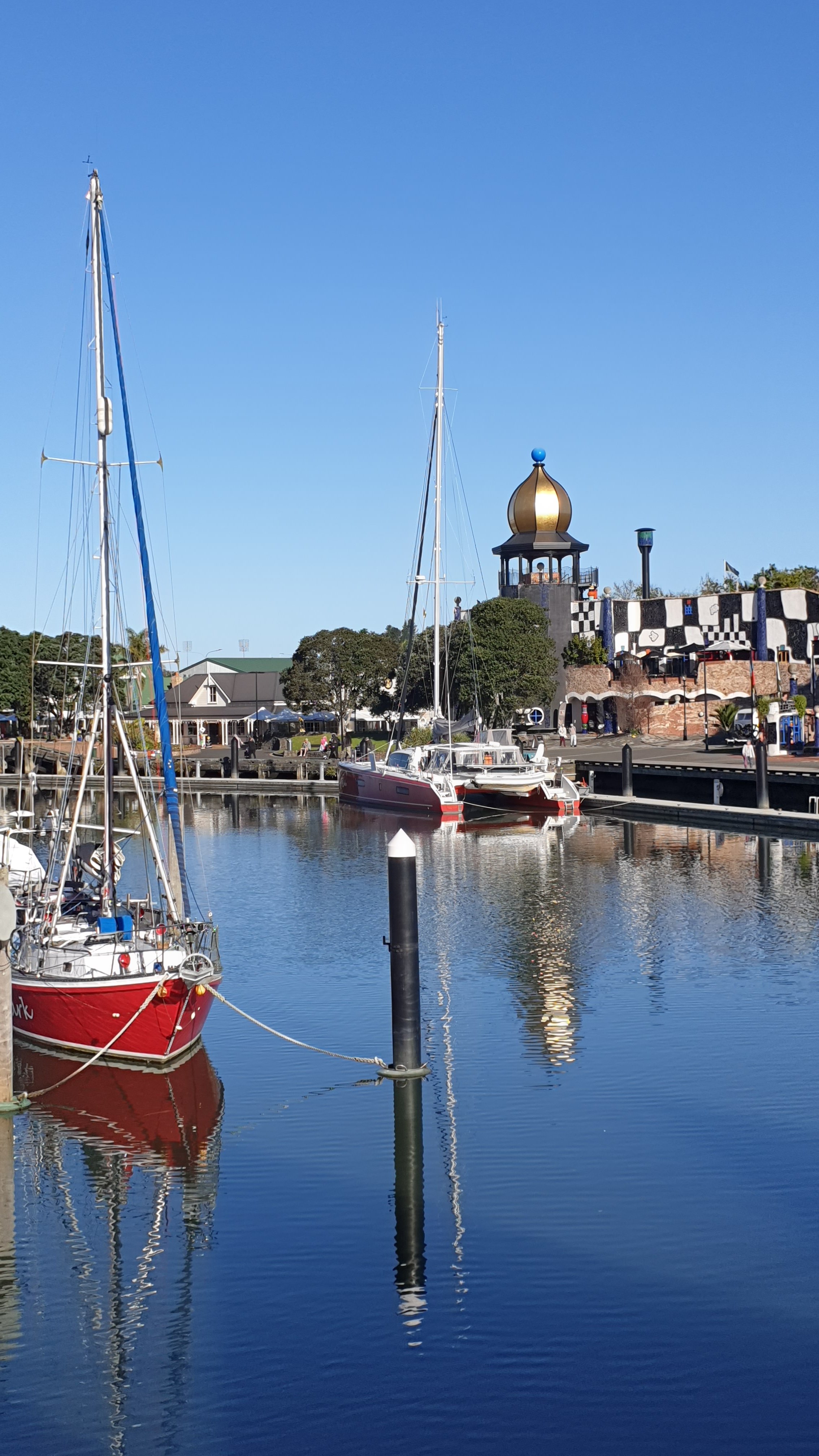 Boats moored in calm water at Whangārei Town Basin under a clear blue sky, reflecting the sense of peace and balance that can come after a major life transition.