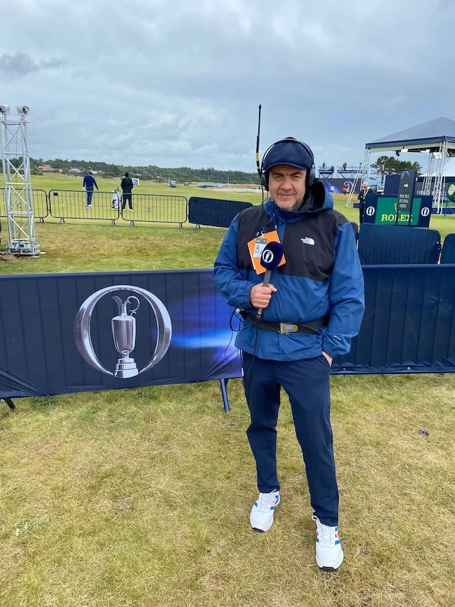 Dave Farrar of Speechless Media, outdoors with a microphone, commentating at a golf event.