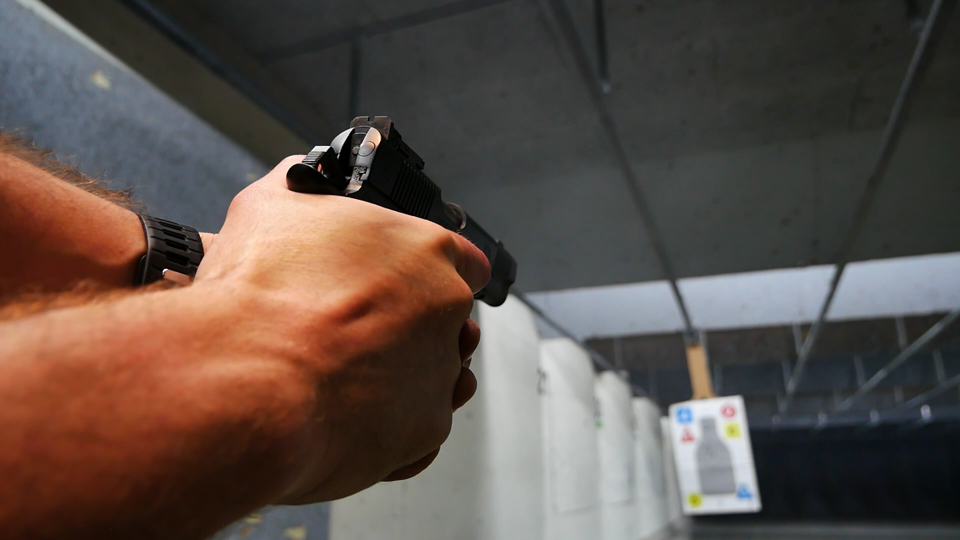 POV of a Jacob Grey TWC9 handgun being fired down range at a UPSCA/IPSC paper target at an indoor range in Bellevue Washington.