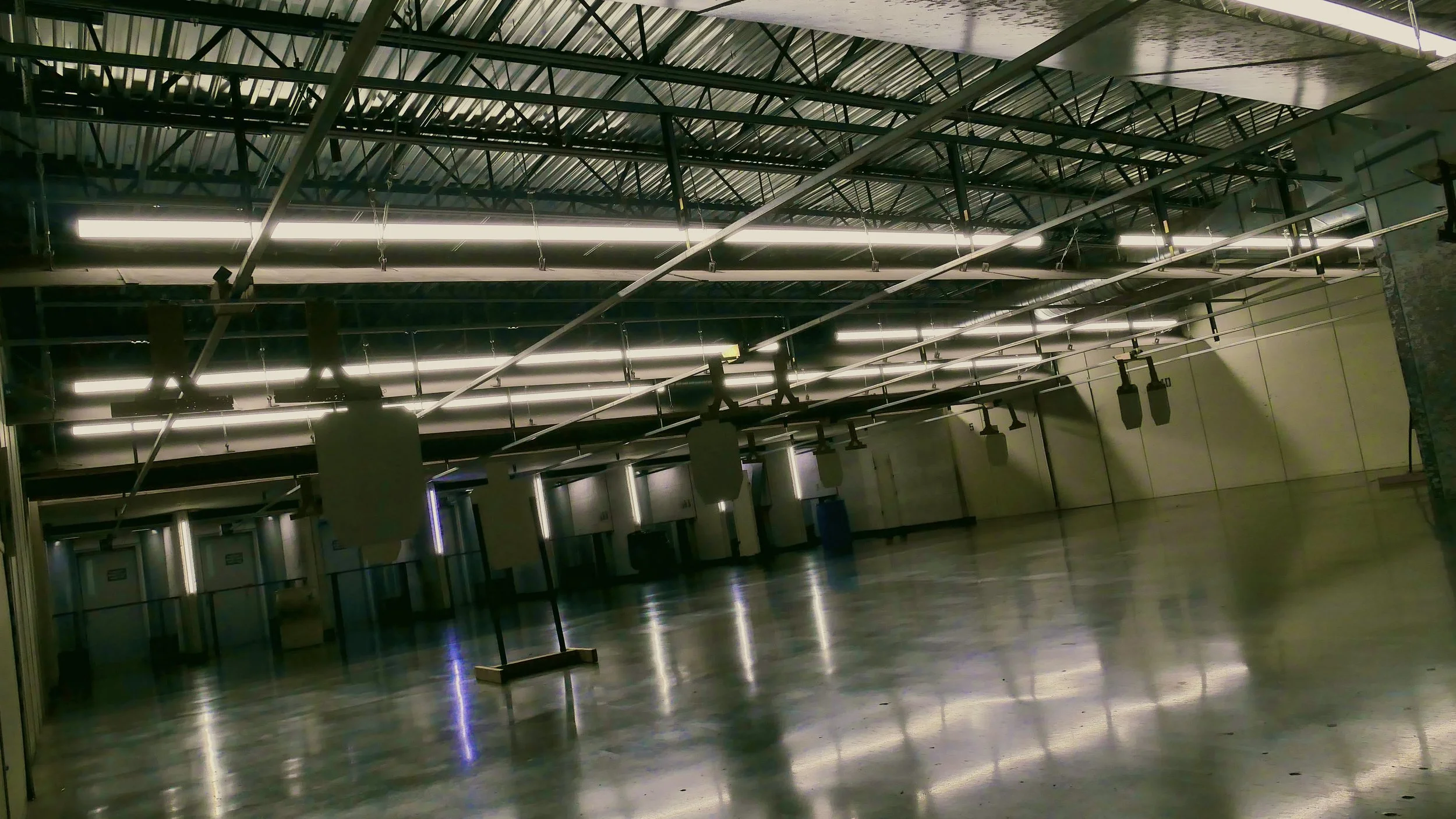 View of a shooting range from the perspective of the range itself. The view shows the front end of the private shooting booths at an indoor range.