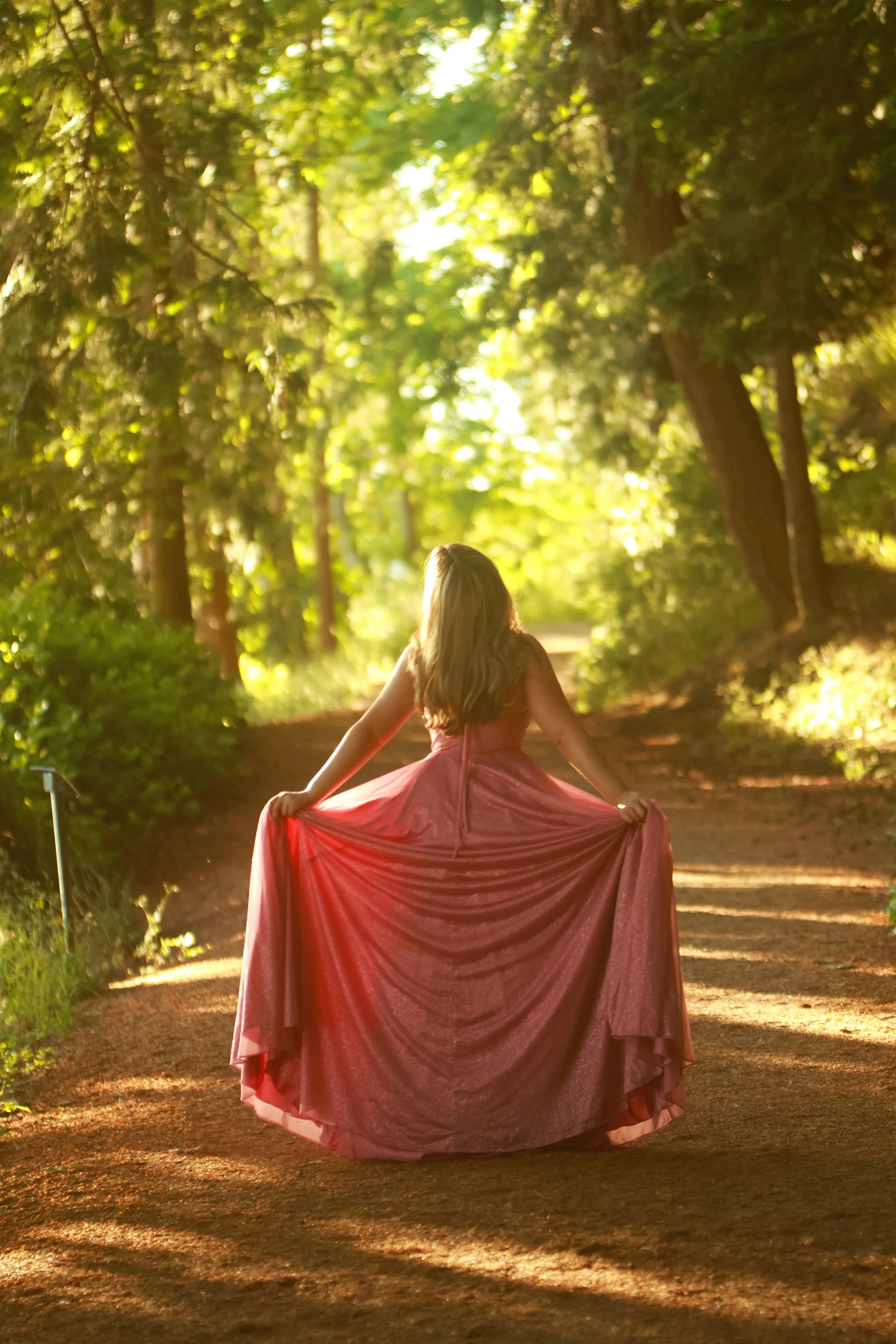 A female grad on a forest trail