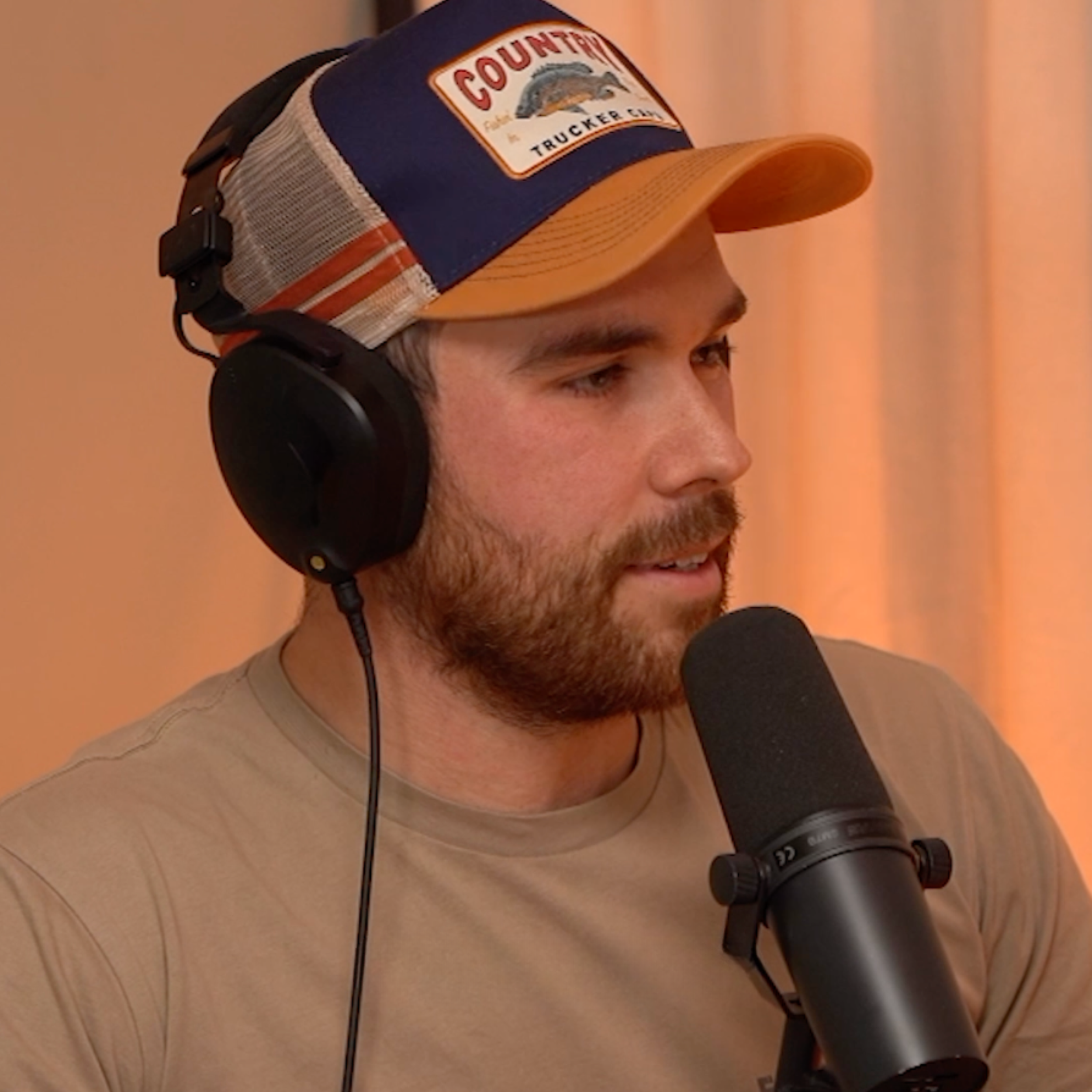 Ben Pettingill sitting behind a microphone for his podcast Flying Blind