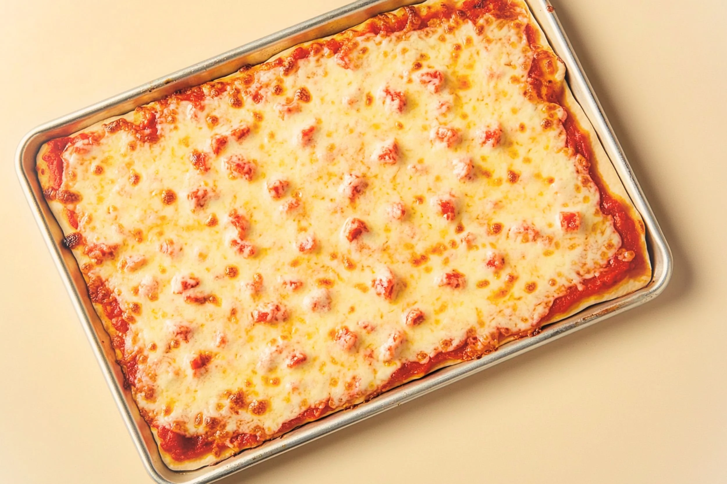 Homemade rectangle cafeteria school pizza in a 9x13 pan with melted mozzarella, diced pepperoni, and thick soft dough