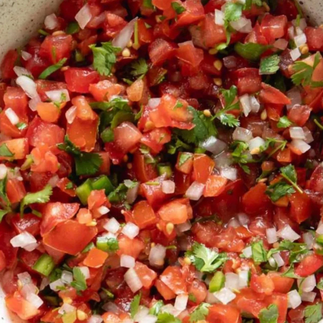 Fresh homemade pico de gallo made with diced tomatoes, onion, cilantro, and jalapeño mixed in a bowl.